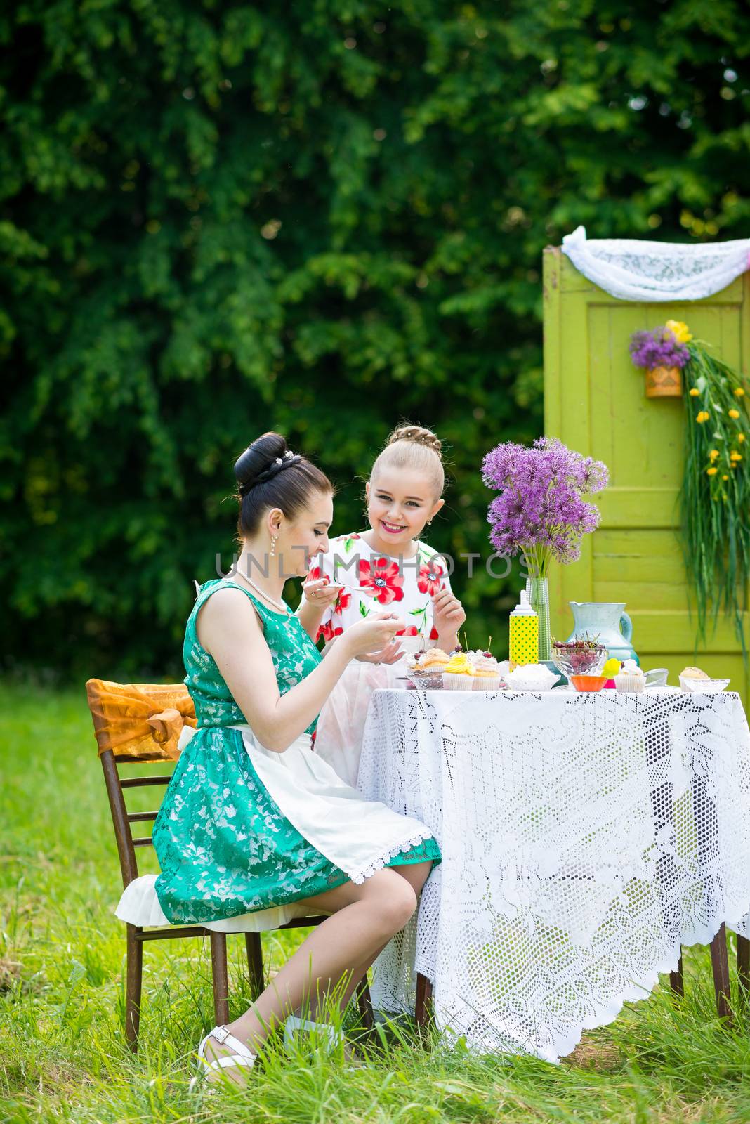 mother with daughter have a breakfast in the garden