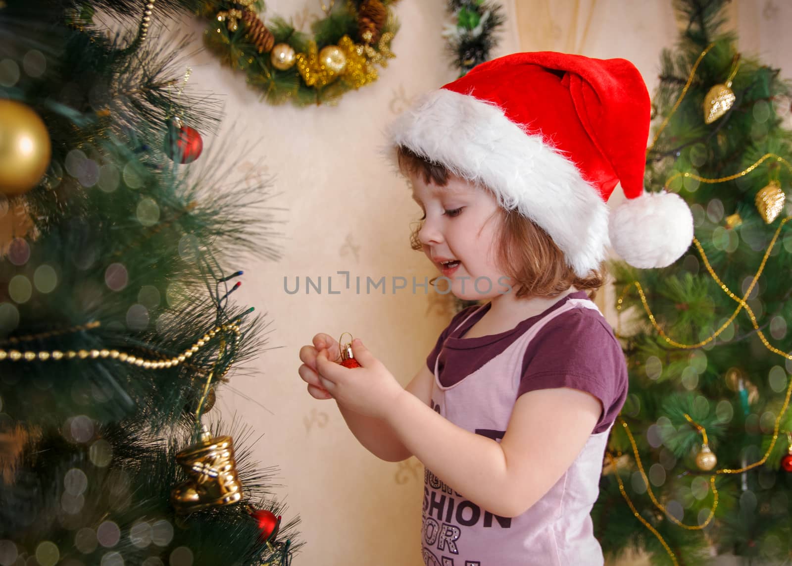 Girl decorating Christmas tree in red cap by Angel_a