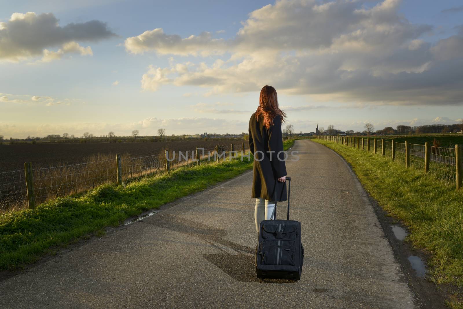 runaway girl standing with her suitcase on the road by itsajoop