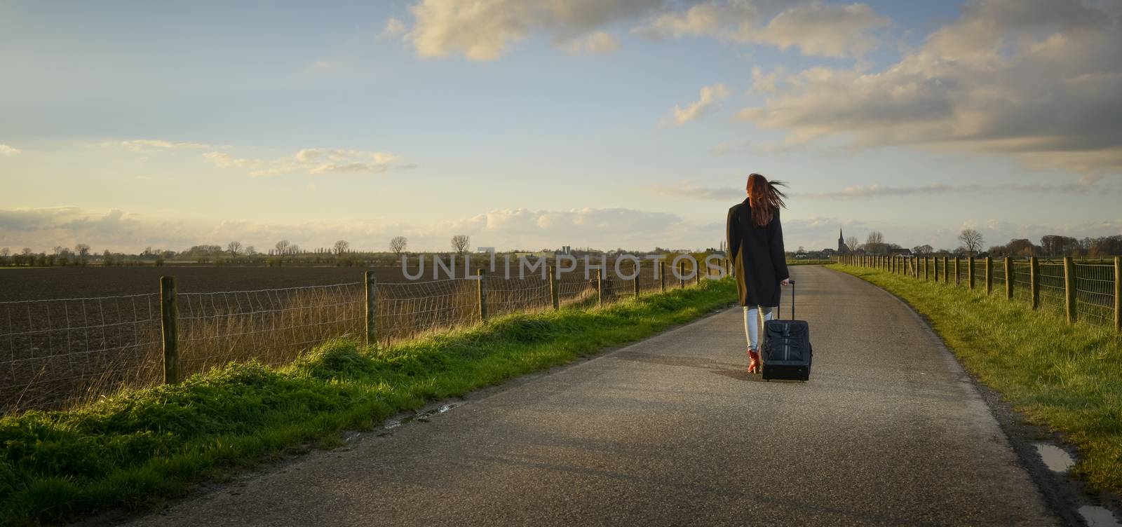 runaway girl standing with her suitcase on the road by itsajoop