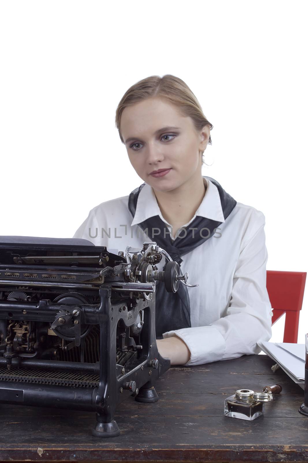 Young girl typist with an old typewriter on a white background