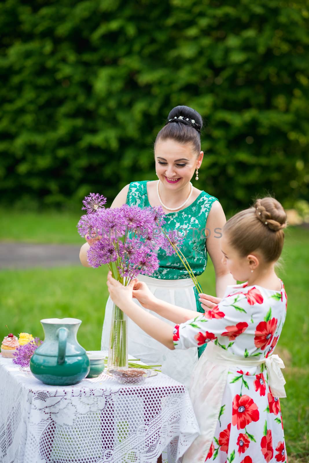 mother with daughter have a breakfast in the garden