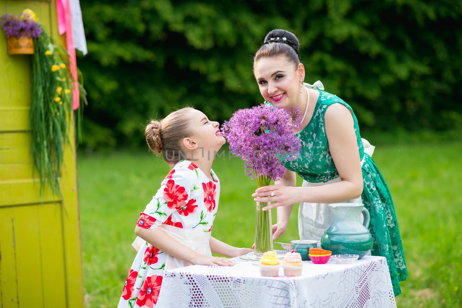 mother with daughter have a breakfast in the garden