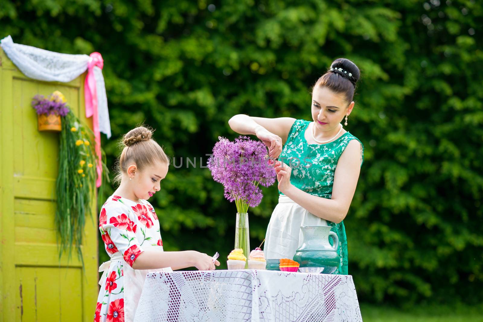 mother with daughter have a breakfast in the garden