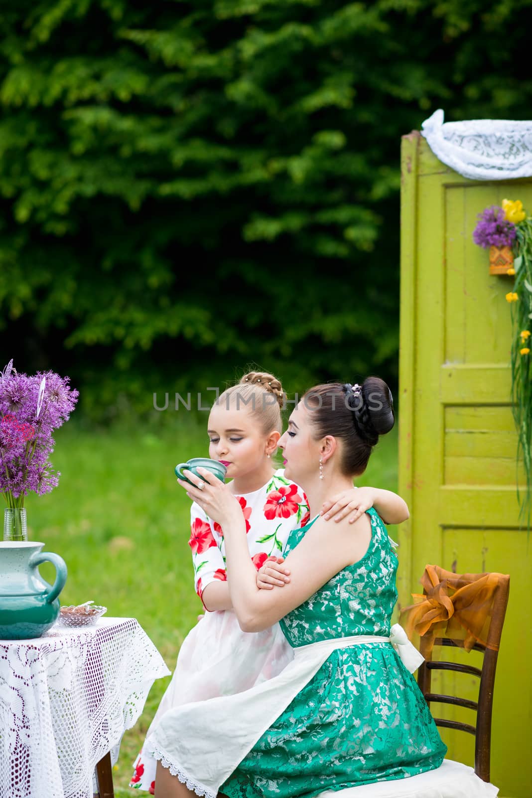 mother with daughter have a breakfast in the garden