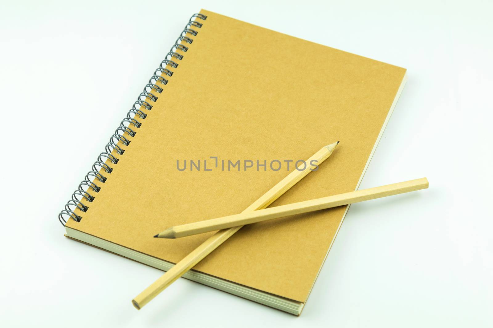 close notebook with pencil on white background by luckyfim