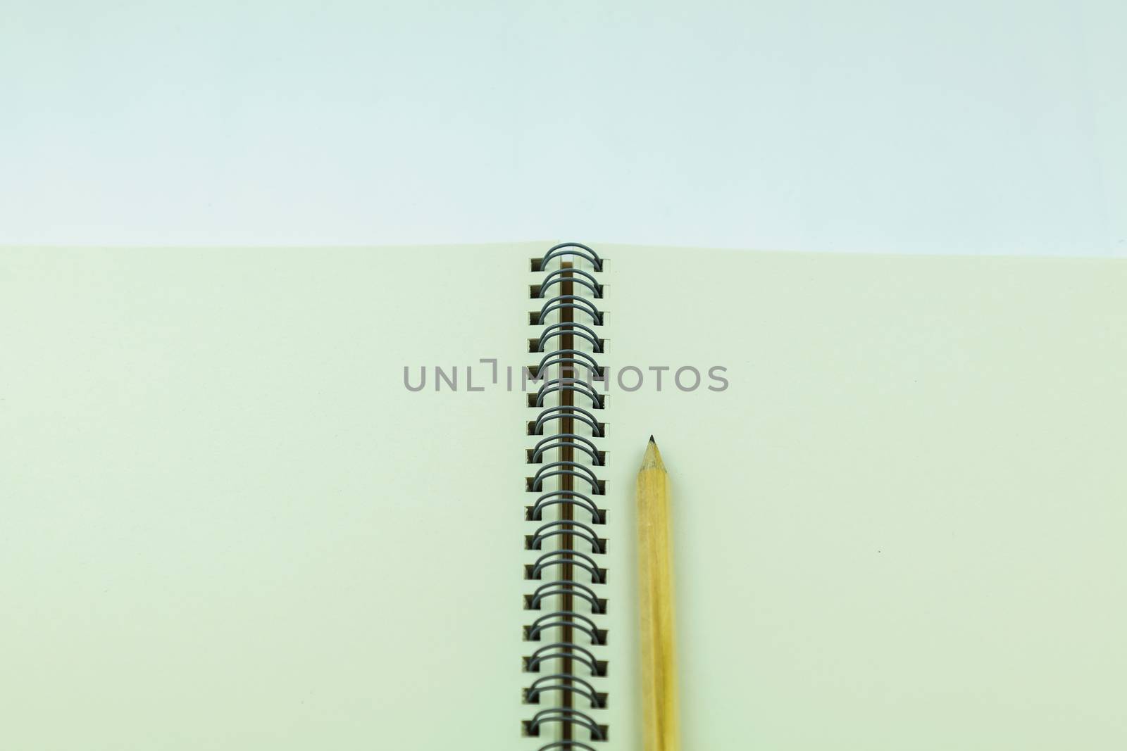 open notebook with pencil on white background by luckyfim