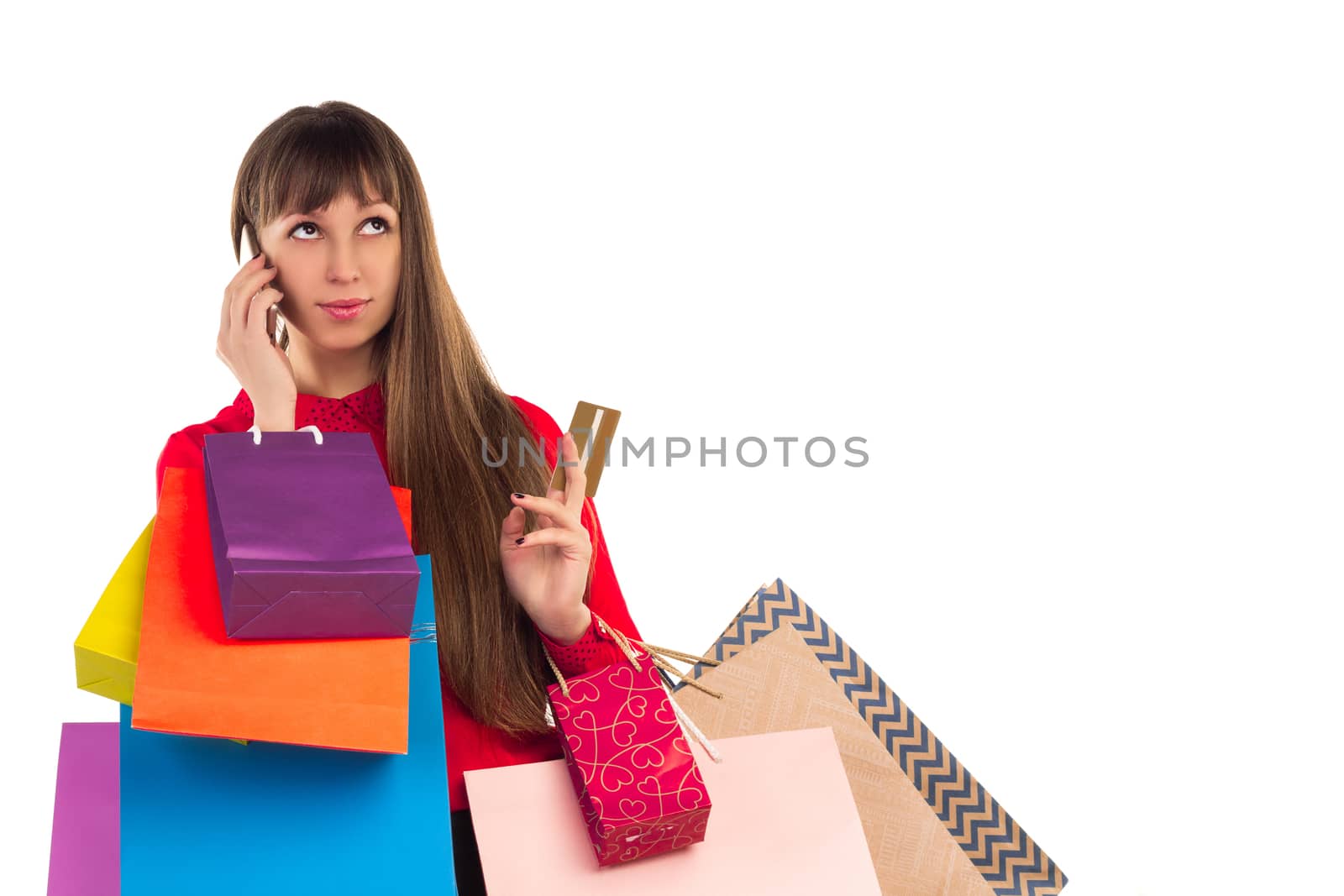 Young woman with banking credit card, colourful shopping paper bags and packages, smartphone