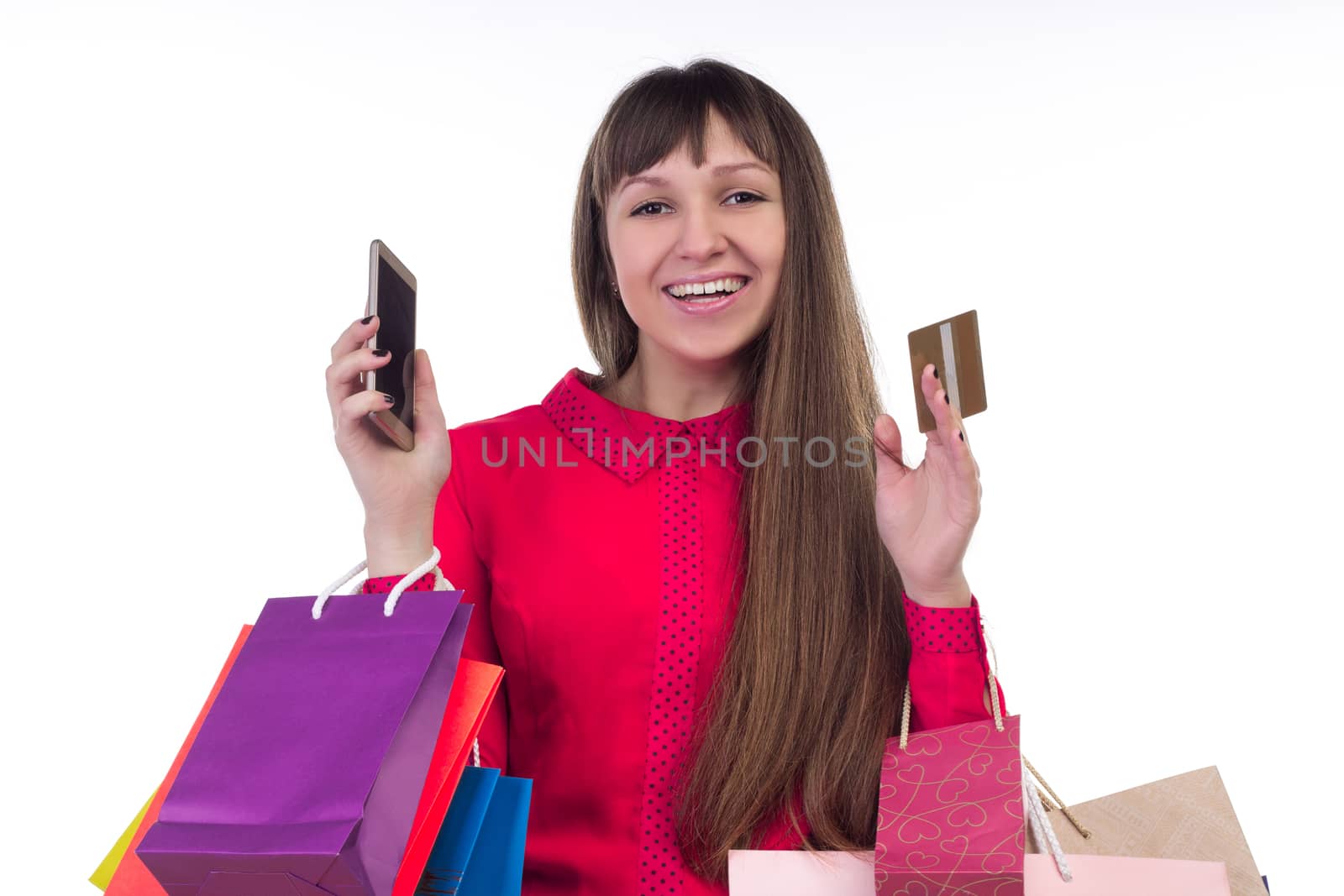 Young woman shopping with credit card holding colourful paper bags, packages and smartphone
