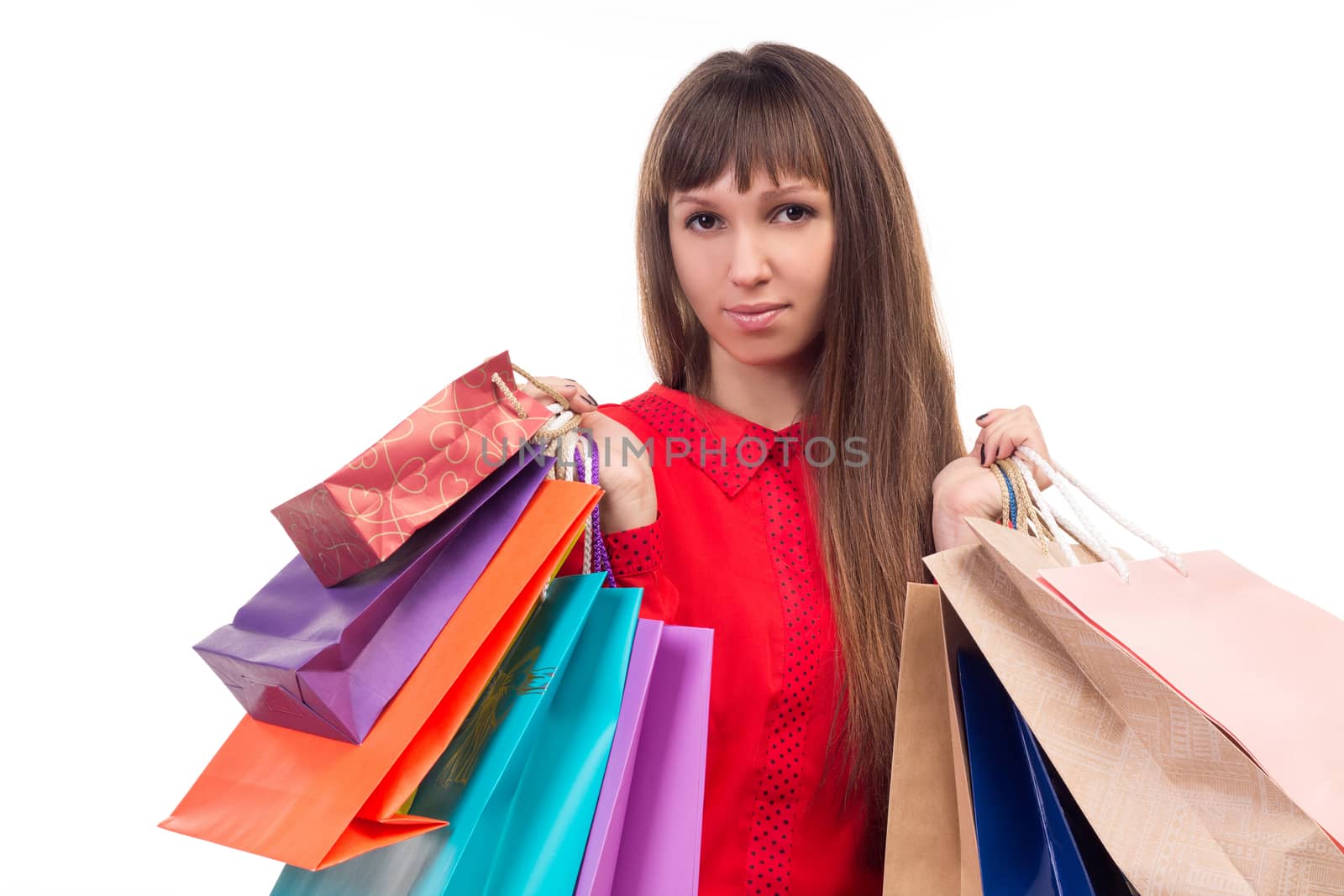 Young long-haired woman holds her purchases, many colorful paper bags, packages in her hands after shopping