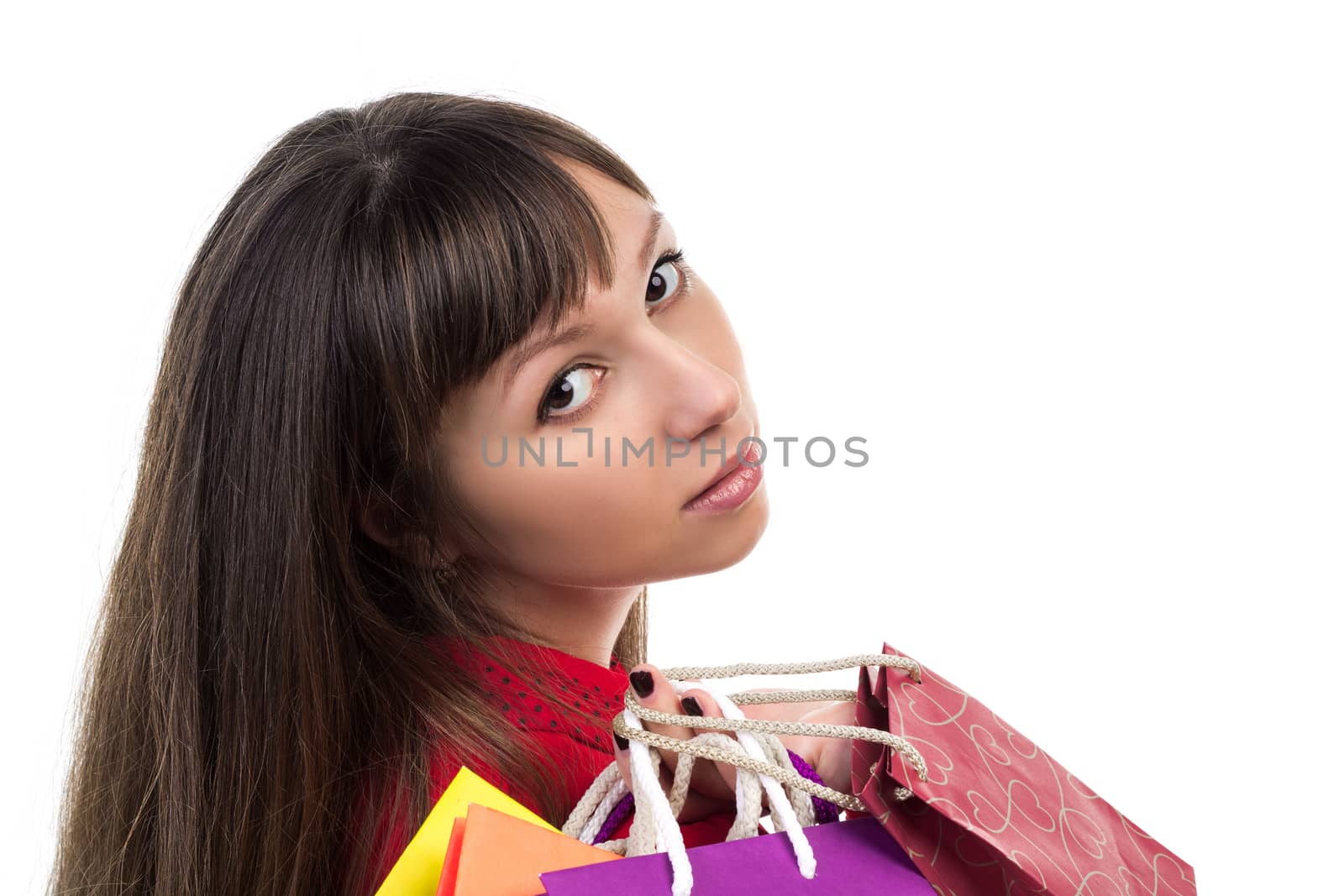 Close-up of young woman face with colourful shopping paper bags and packages