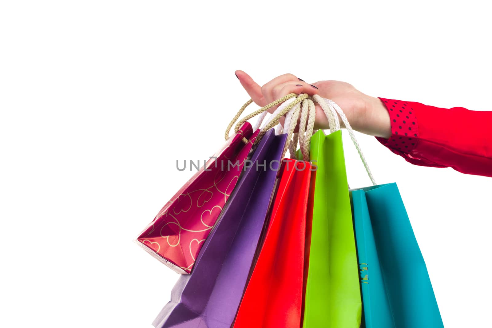 Colourful and bright shopping paper packages hanging on female red-sleeved arm