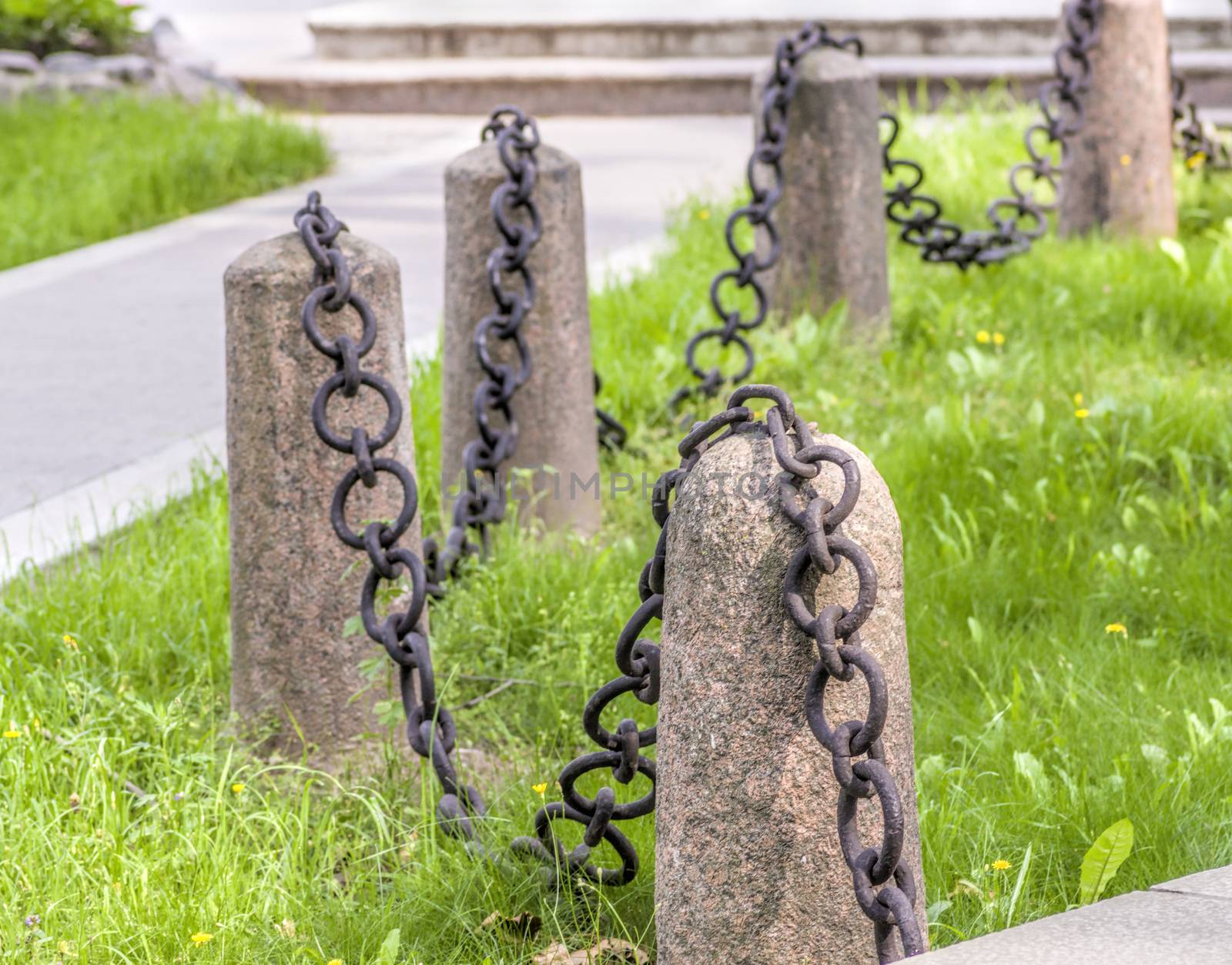 granite pedestal with a chain on a background of green grass old guard