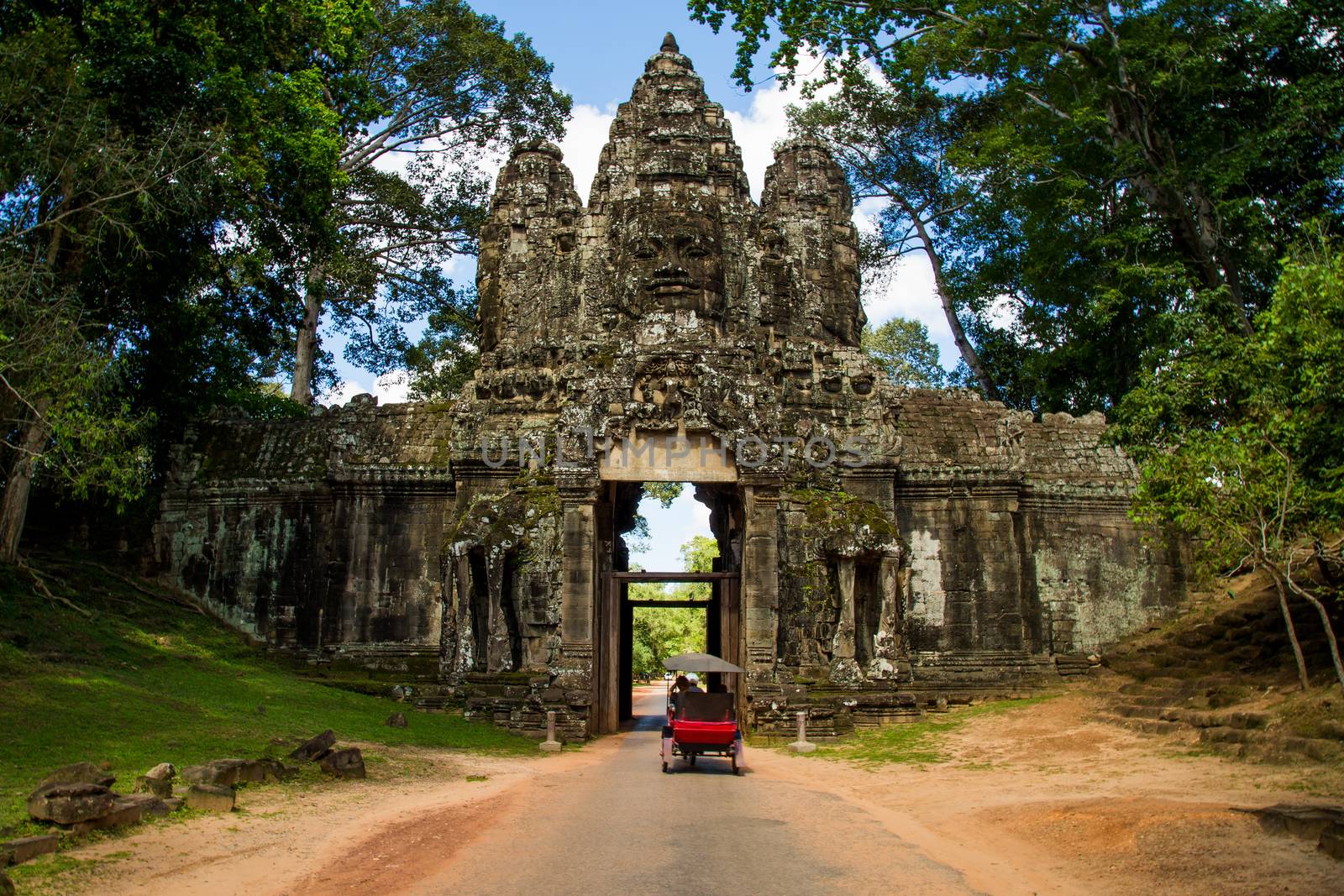 Ankor wat temple wall with tuk tuk on a road