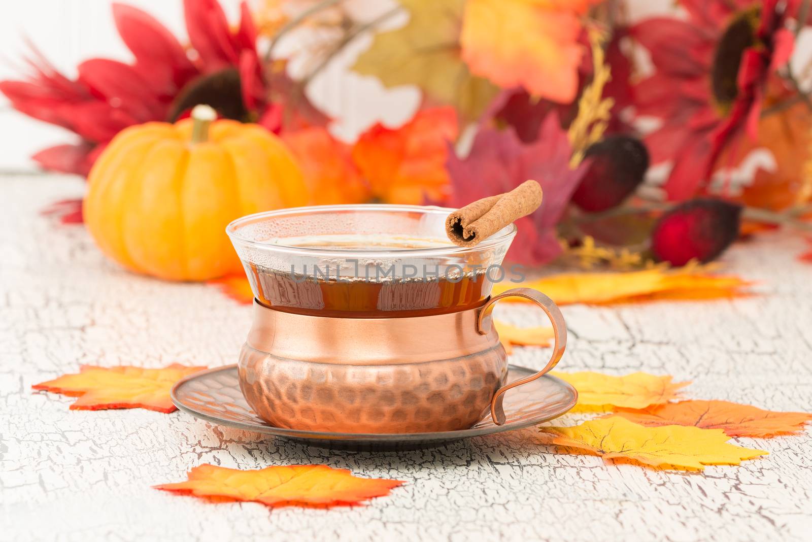 Cup of hot chai tea with a colorful autumn background.