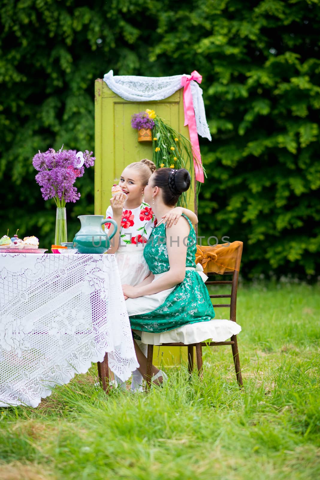 mother with daughter have a breakfast in the garden