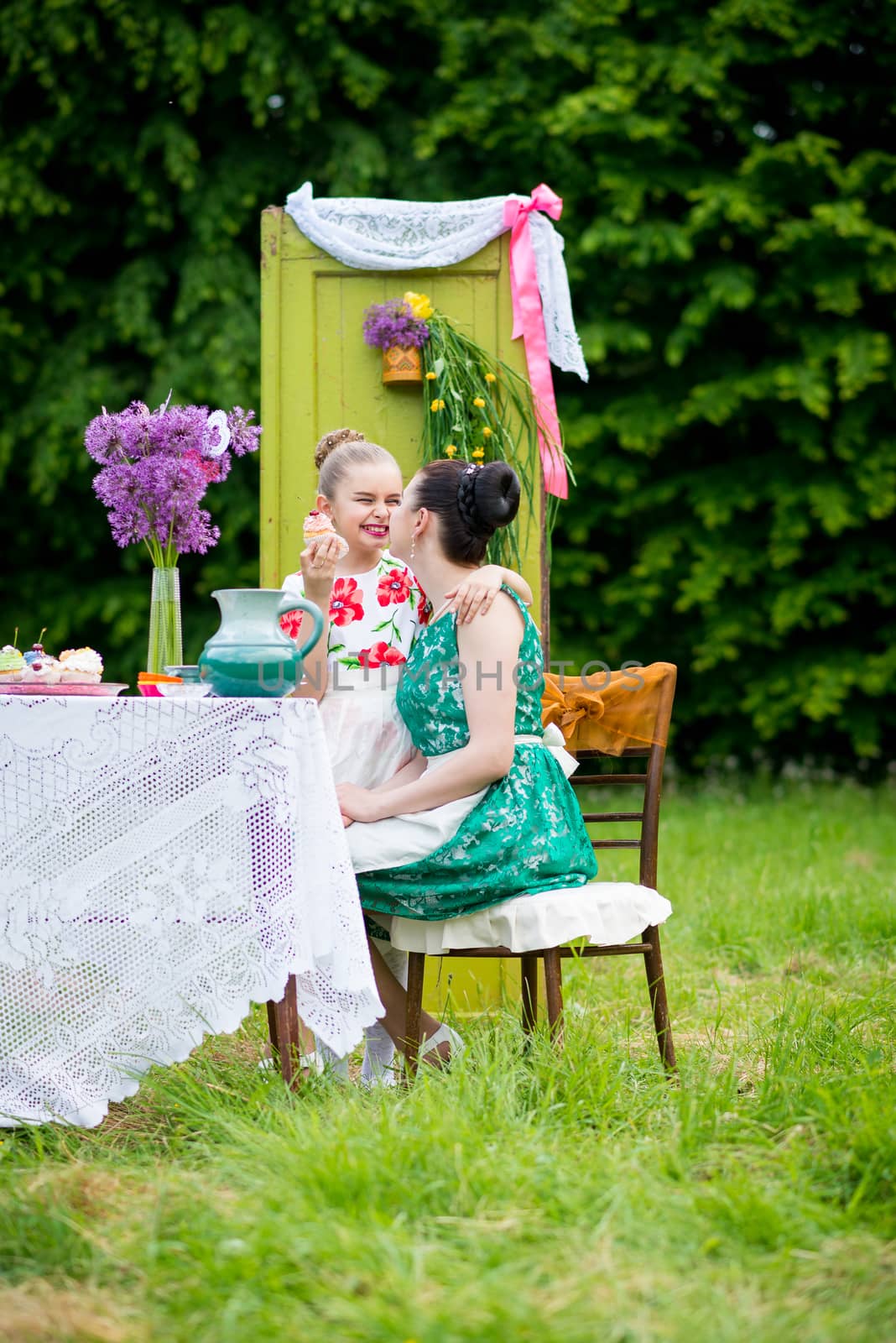 mother with daughter have a breakfast in the garden