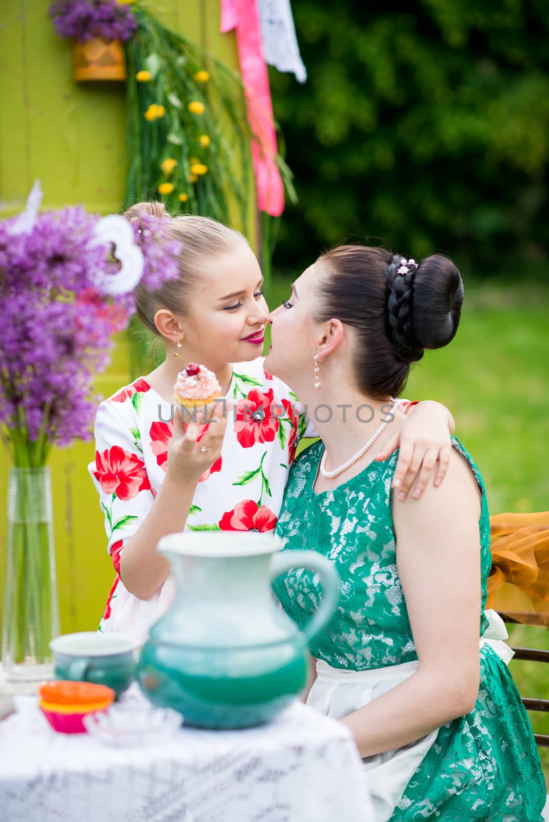 mother with daughter have a breakfast in the garden