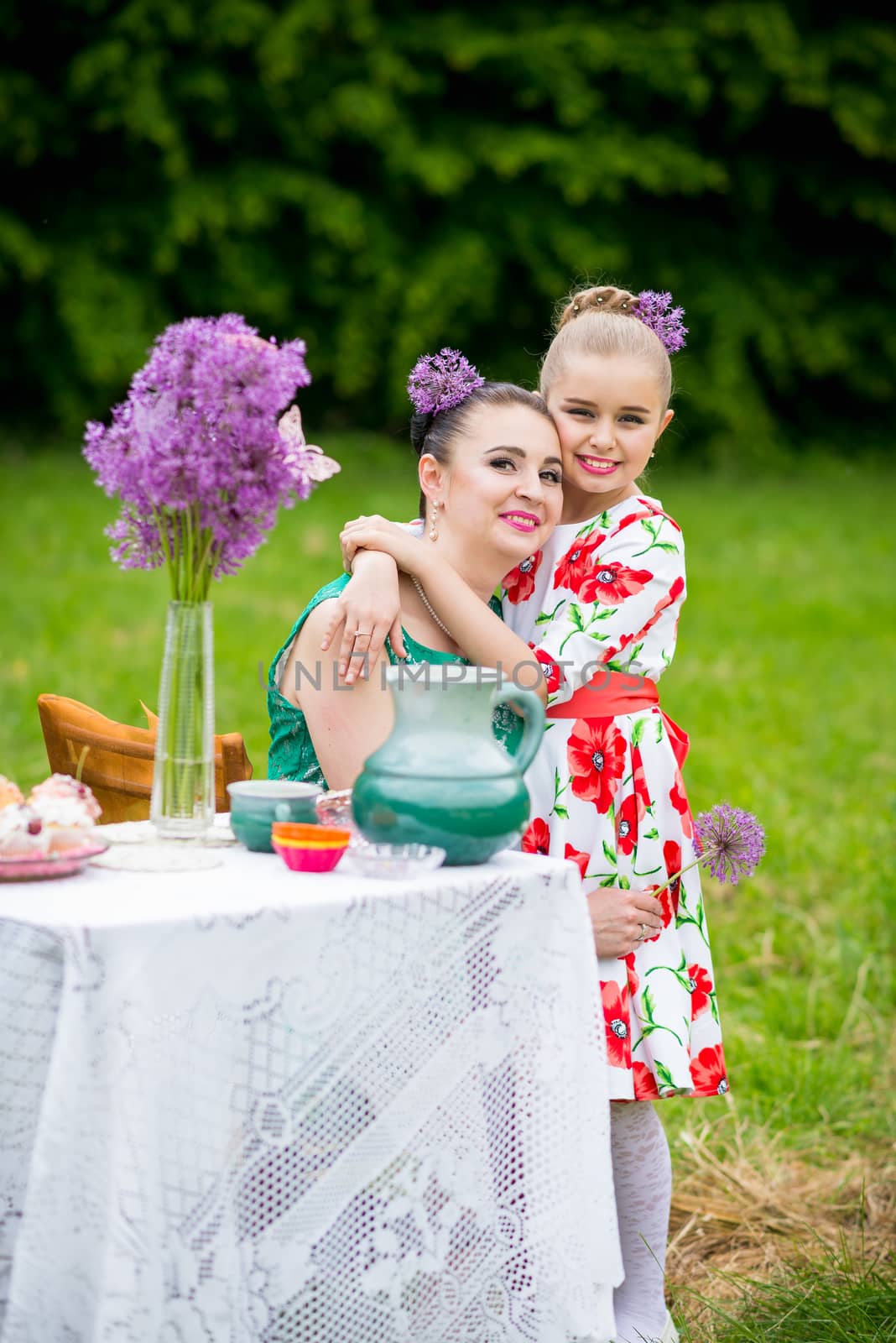 mother with daughter have a breakfast in the garden