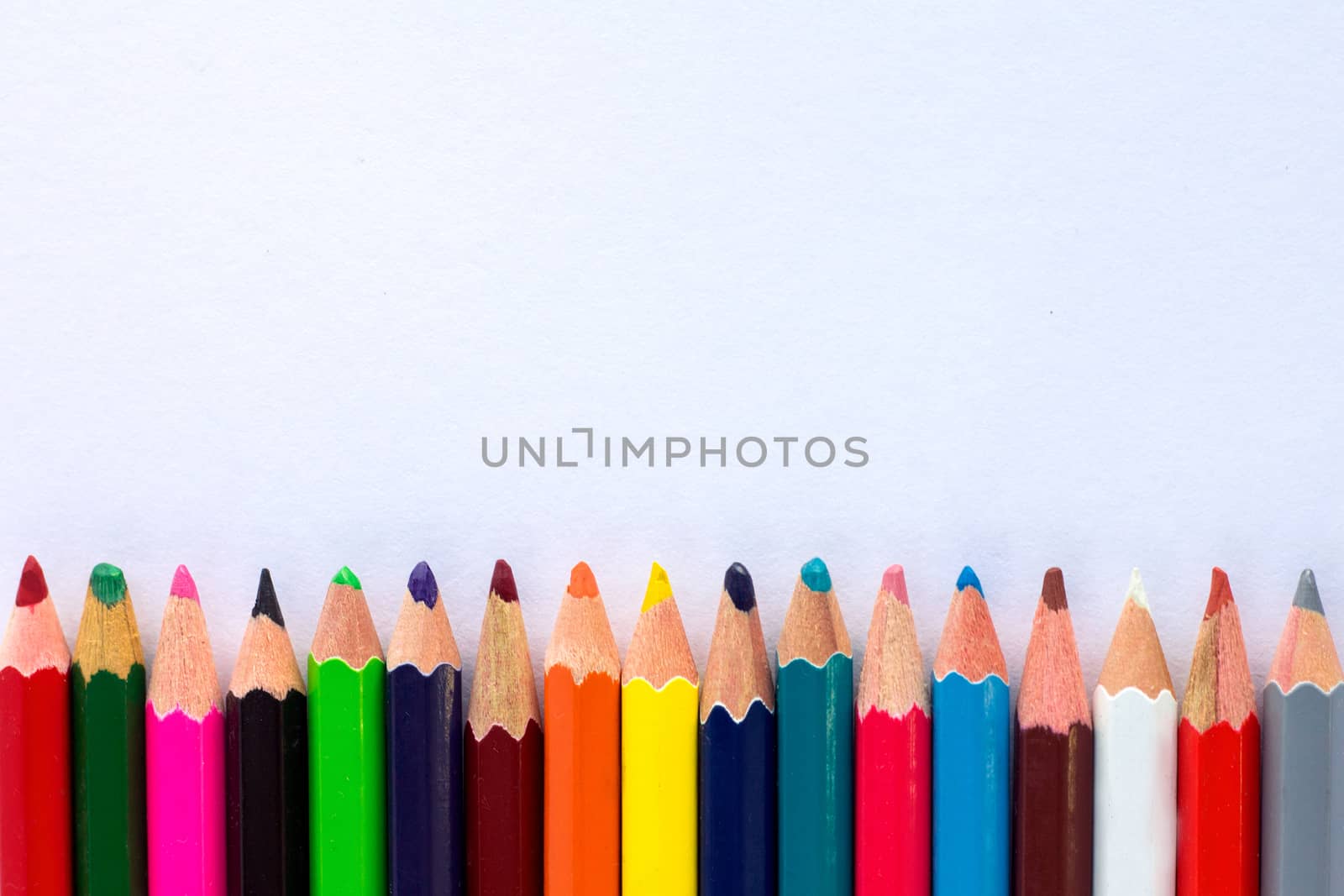 White background for presentation with horizontal colourful bottom border of multicoloured wooden pencils