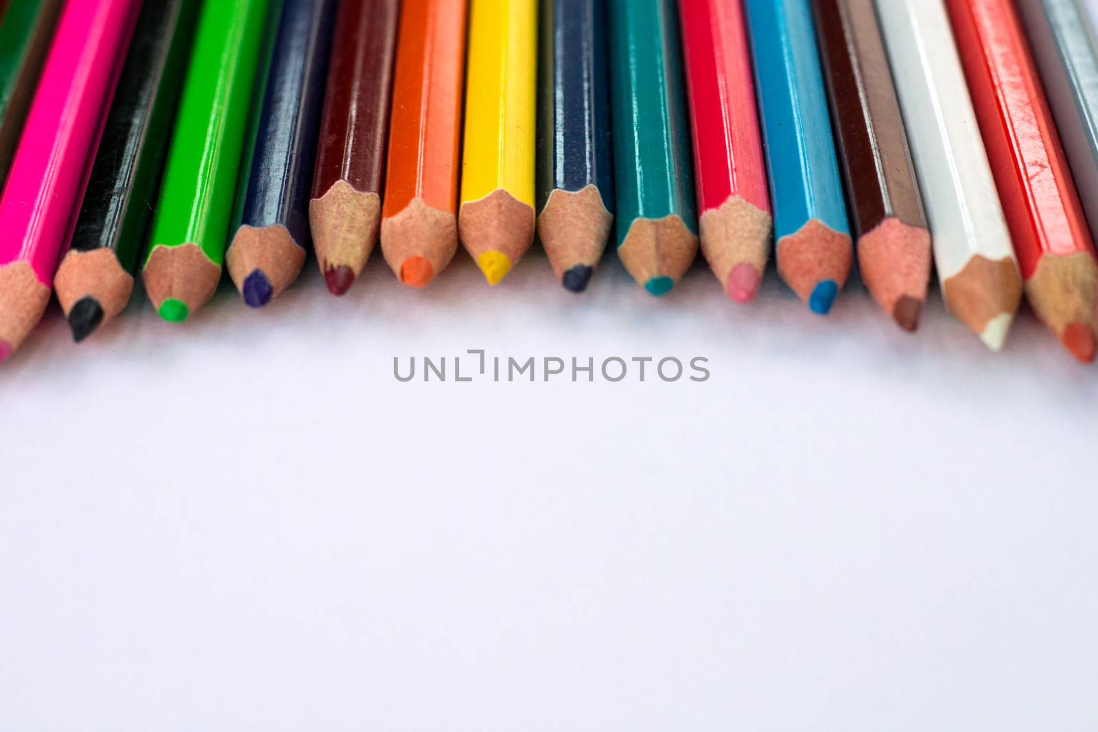 White background for presentation slide with colourful wooden pencils