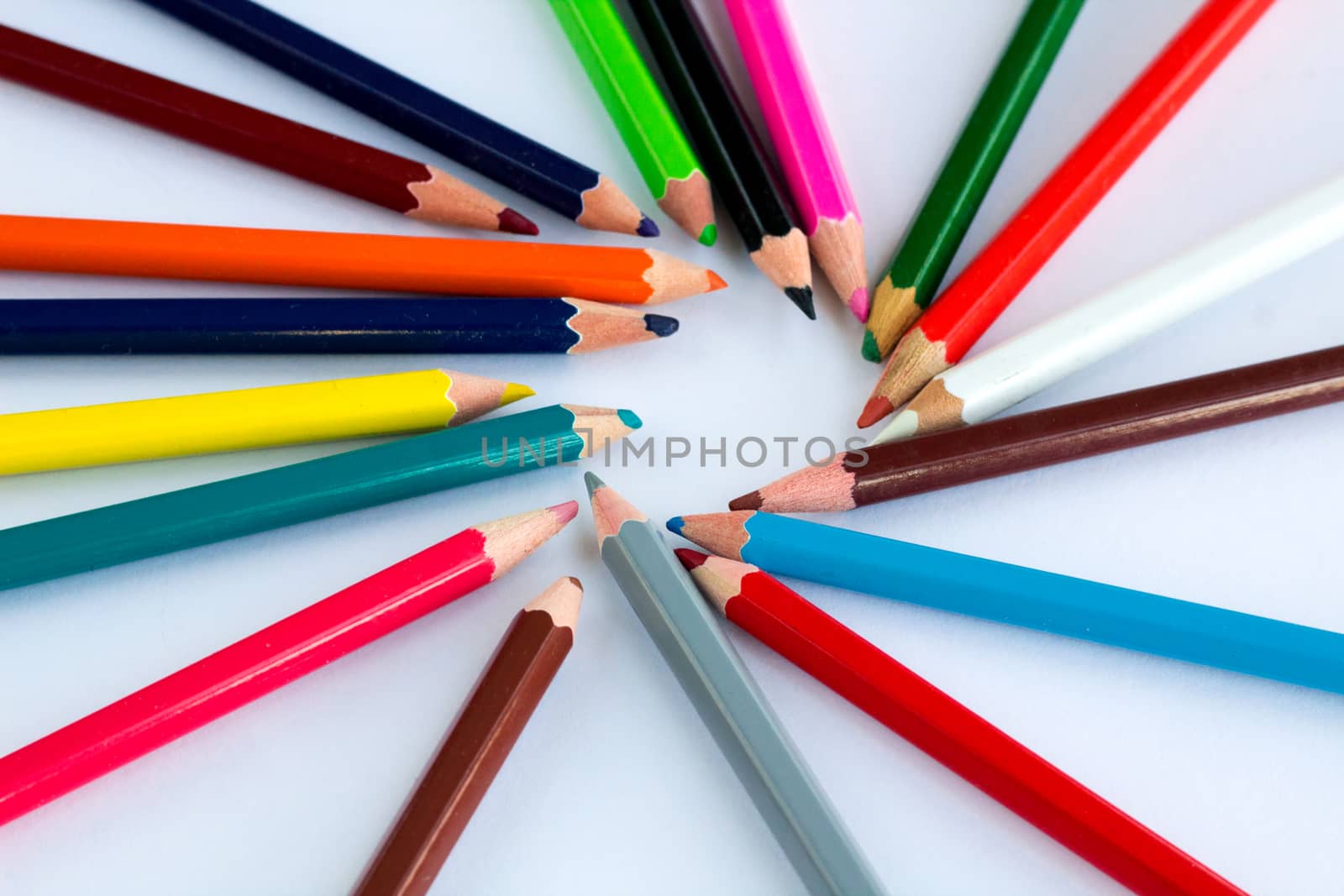 Colourful circle of wooden pencils on white background with copy space