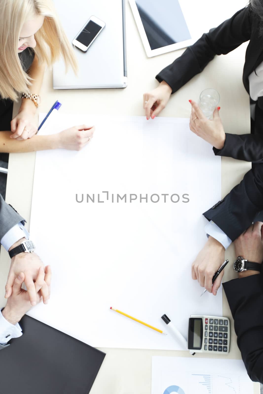 Business people sitting at table with electronic devices on meeting