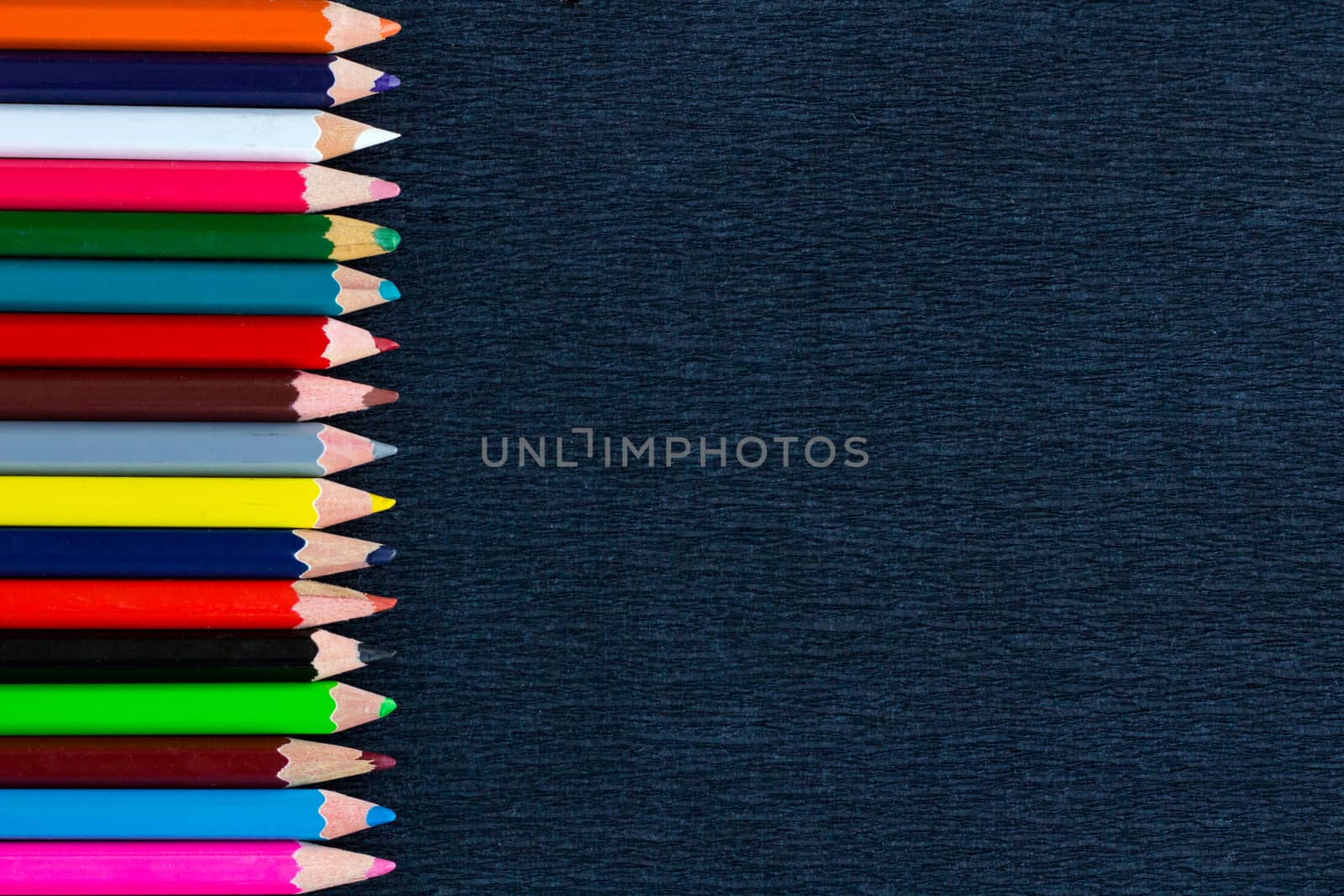 Black background for presentation with vertical colourful right border of multicoloured wooden pencils