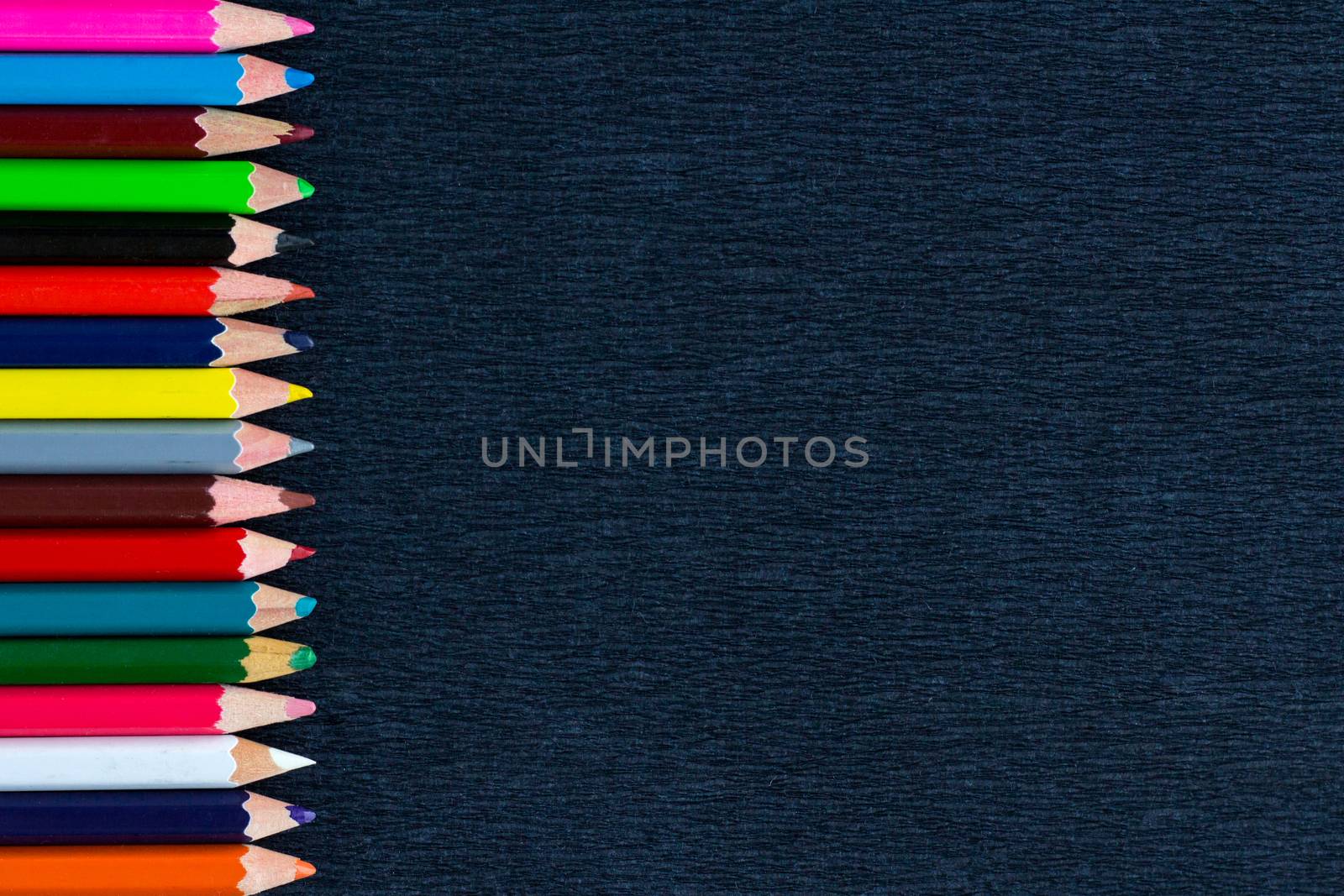 Black background for presentation with vertical colourful right border of multicoloured wooden pencils