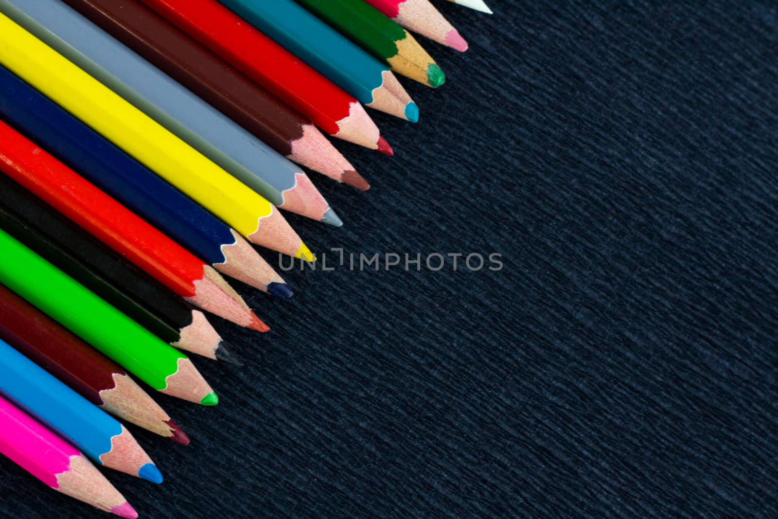 Black background for presentation with colourful right upper corner of multicoloured wooden pencils