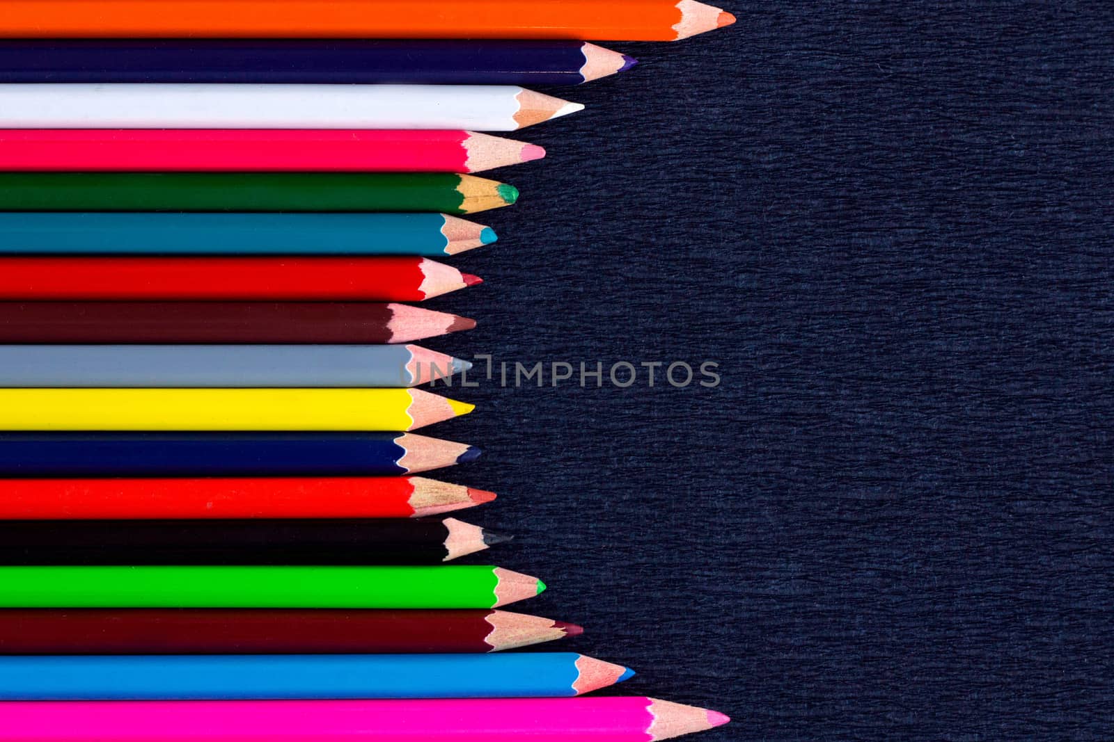 Black background for presentation with vertical colourful right round border of multicoloured wooden pencils
