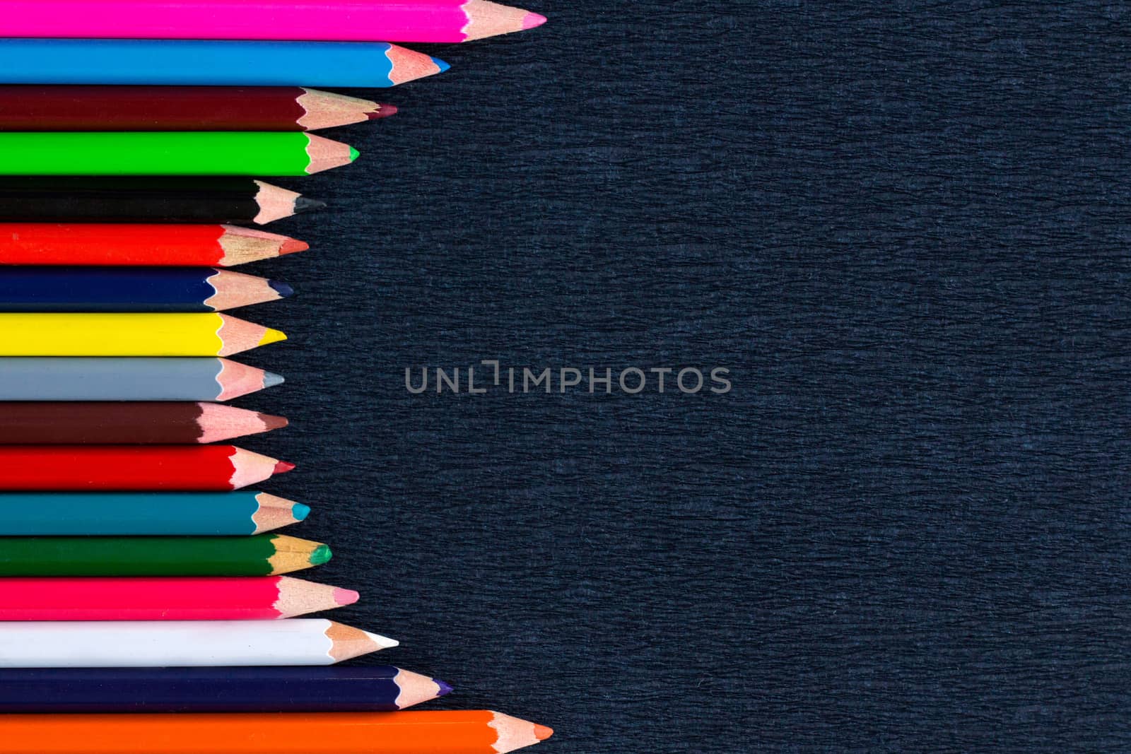 Black background for presentation with vertical colourful right round border of multicoloured wooden pencils