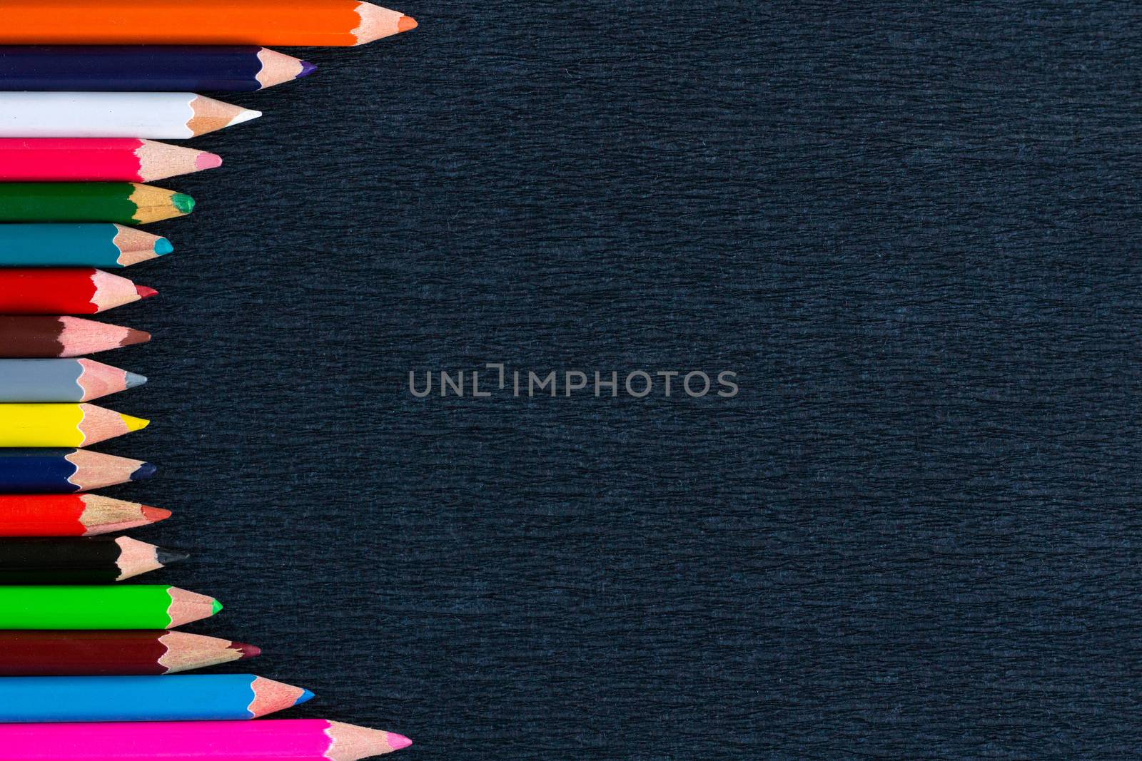 Black background for presentation with vertical colourful right round border of multicoloured wooden pencils