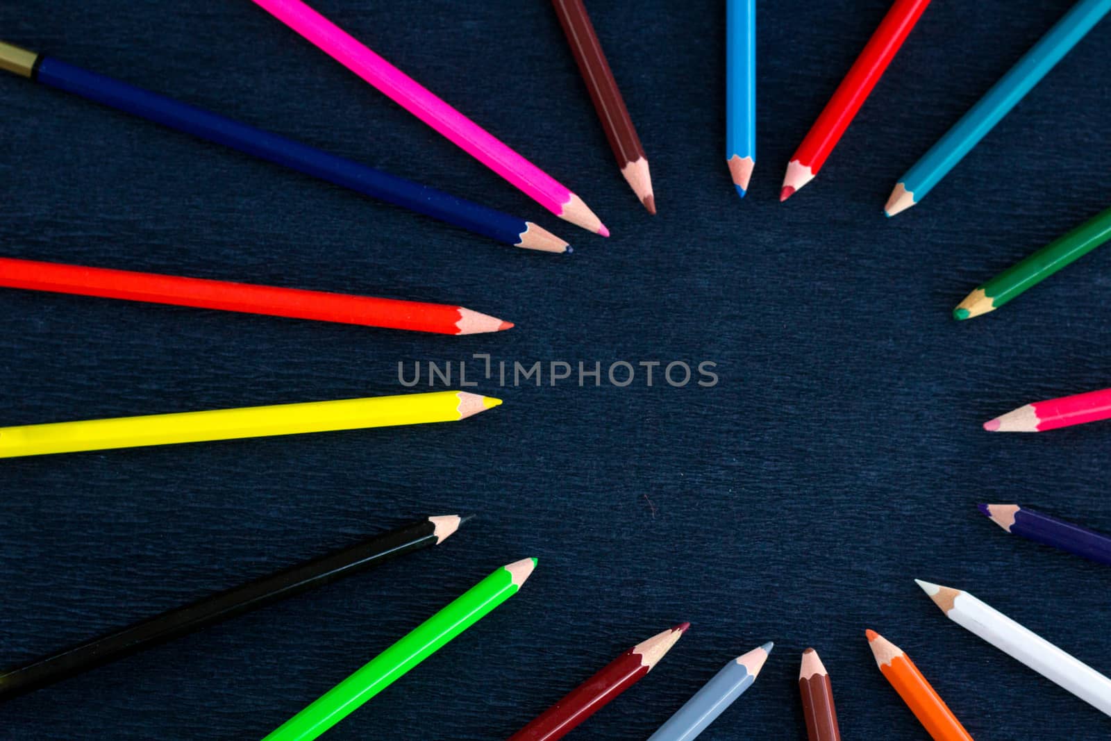 Black background for presentation slide with colourful wooden pencils with circle copy space