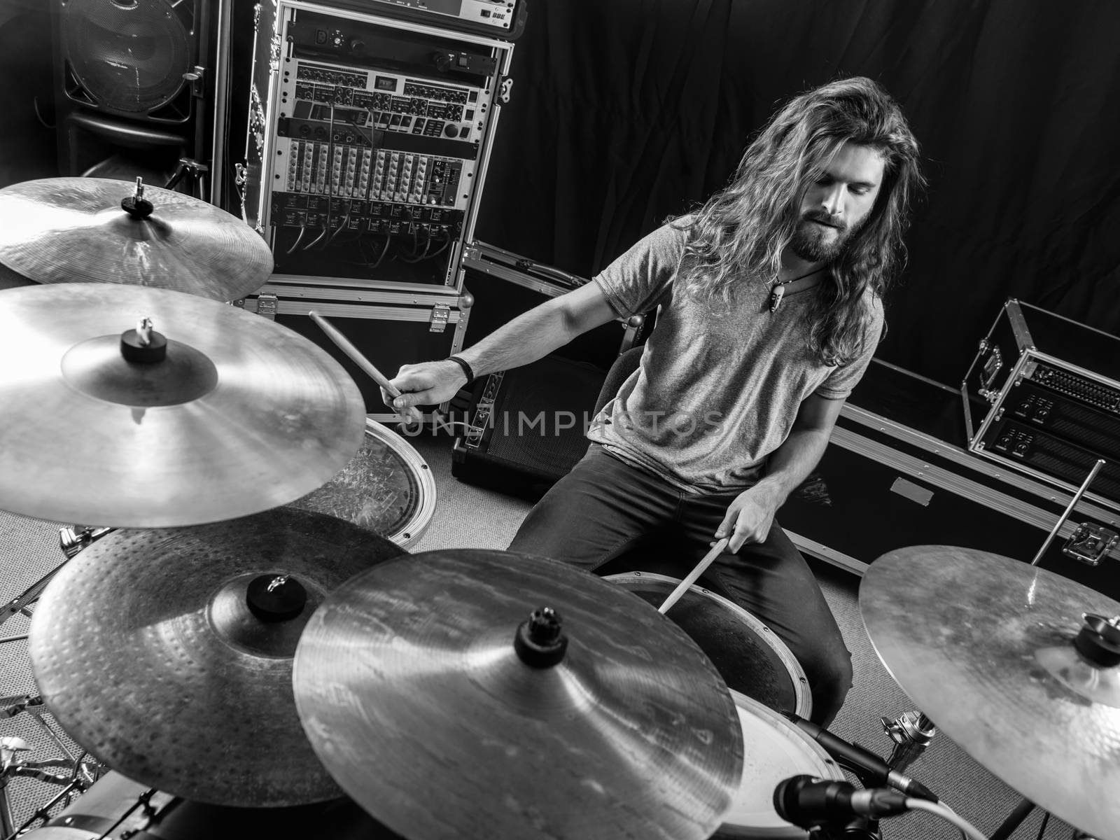 Photo of a male drummer playing his drum set during a concert.