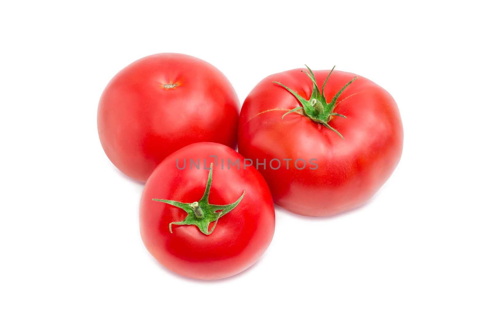 Three ripe red tomatoes closeup on a light background
