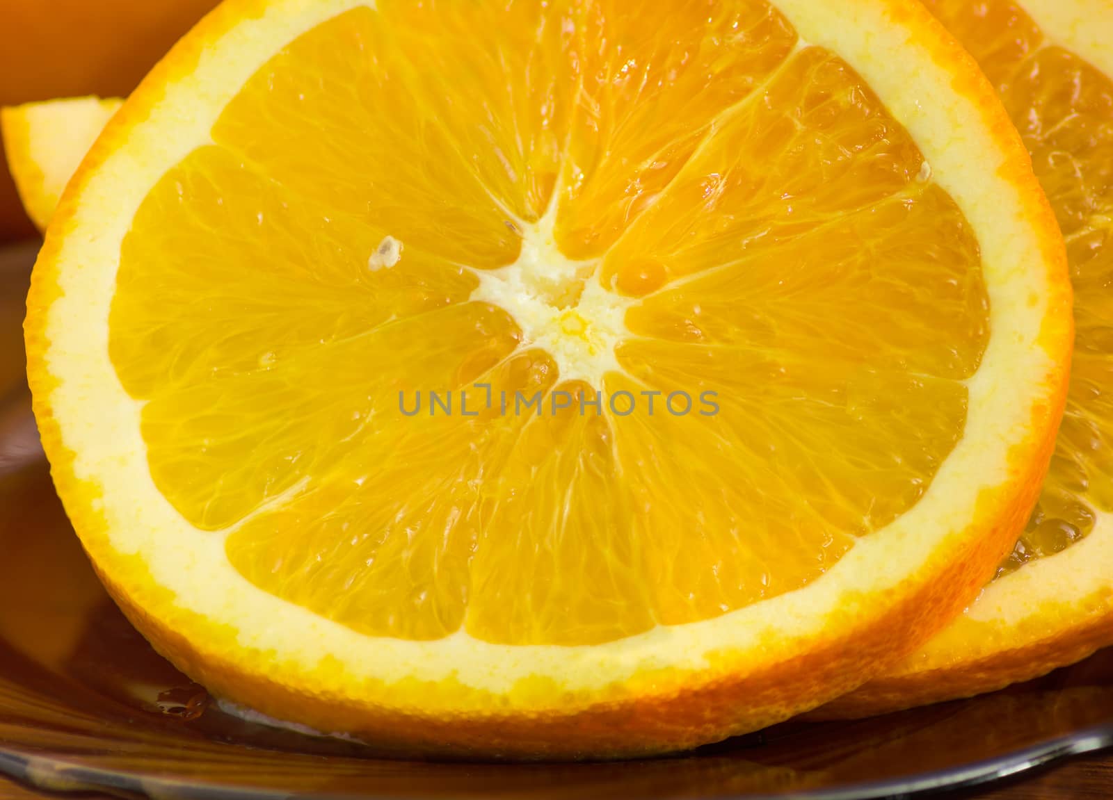 One slice of an fresh orange closeup on the background of other orange slice
