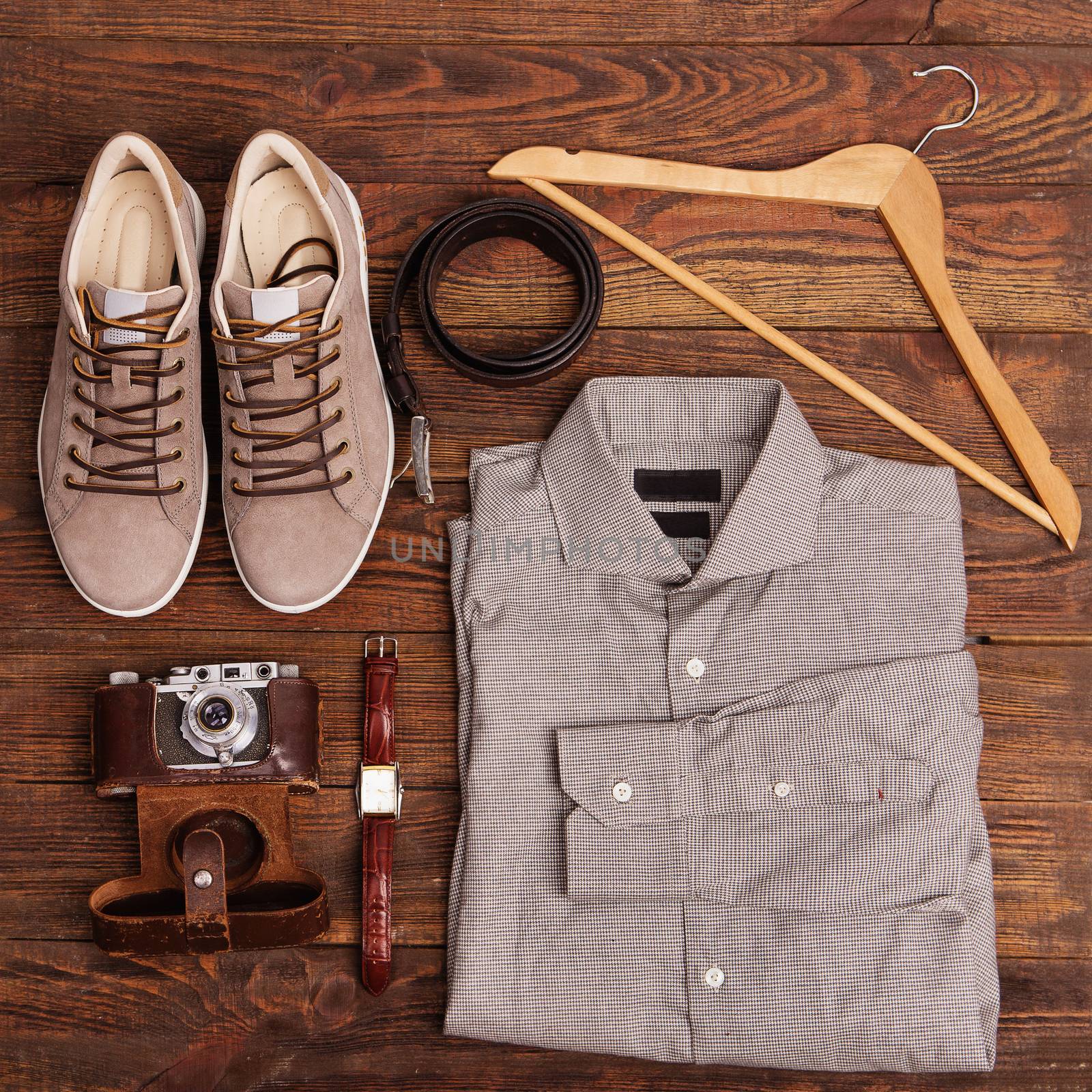 Flat lay of modern men's clothing on a brown wooden background by natazhekova