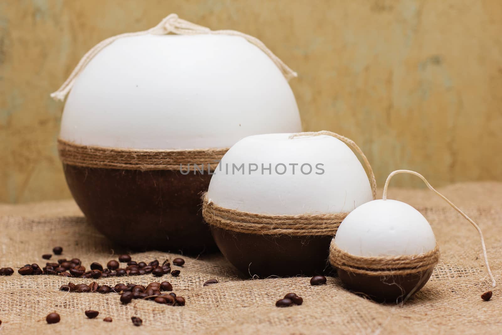 Decorative Handmade candles on textured sackcloth surface.