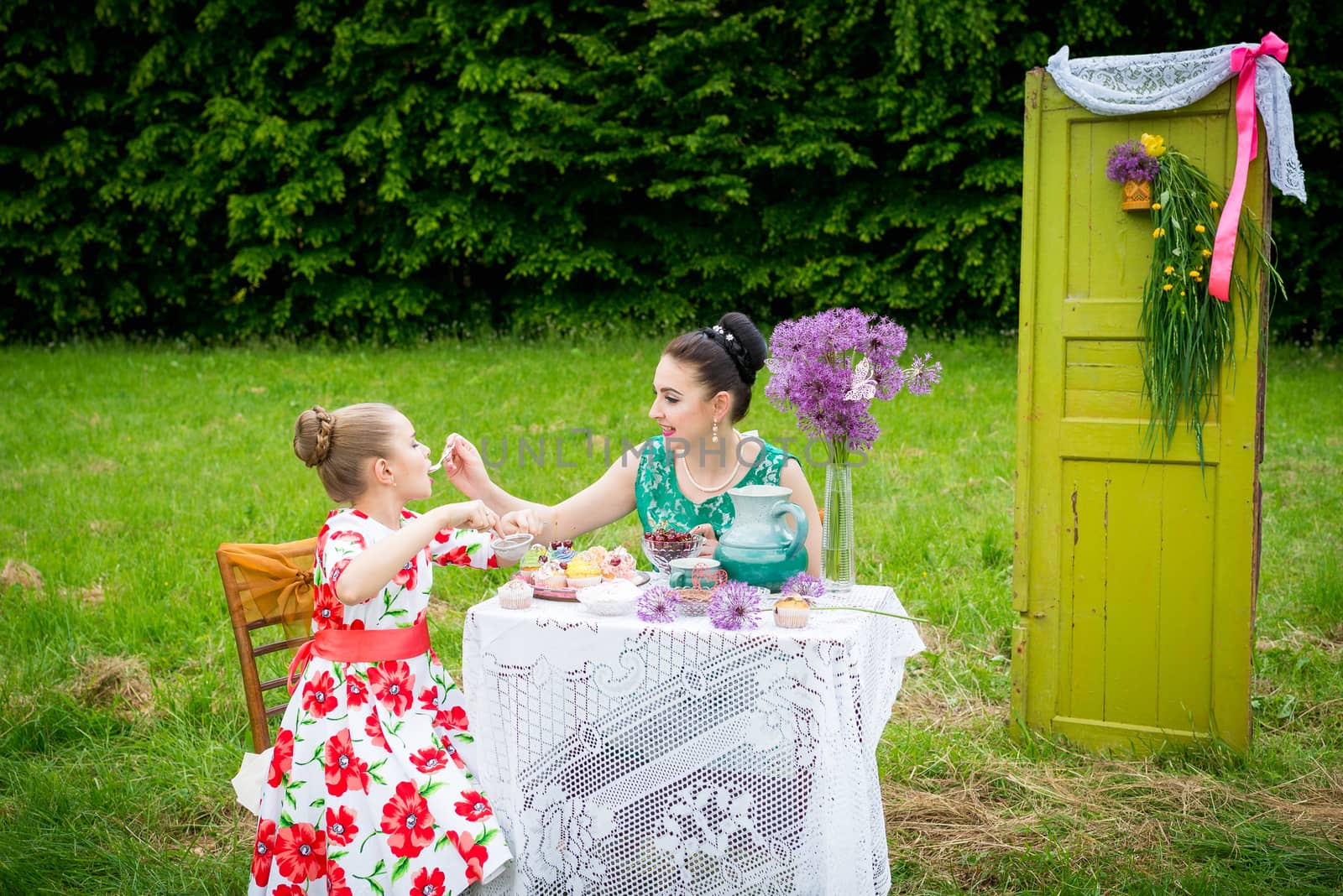 mother with daughter have a breakfast in the garden