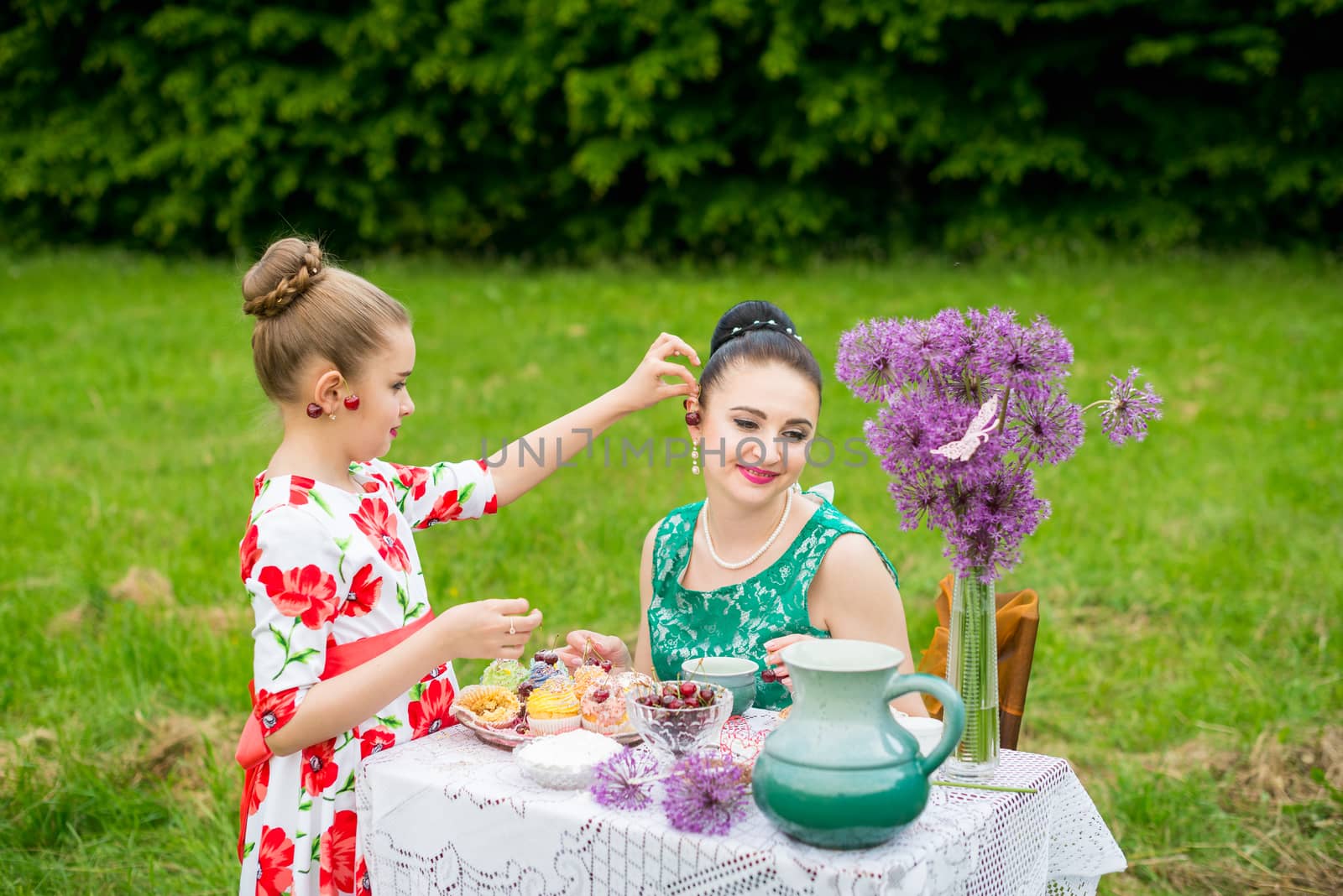 mother with daughter have a breakfast in the garden