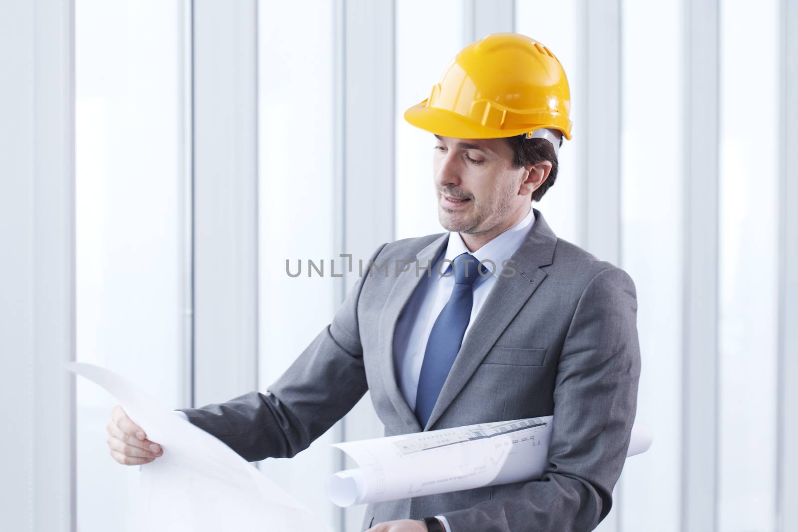 Architector in hardhat and business suit with construction plans