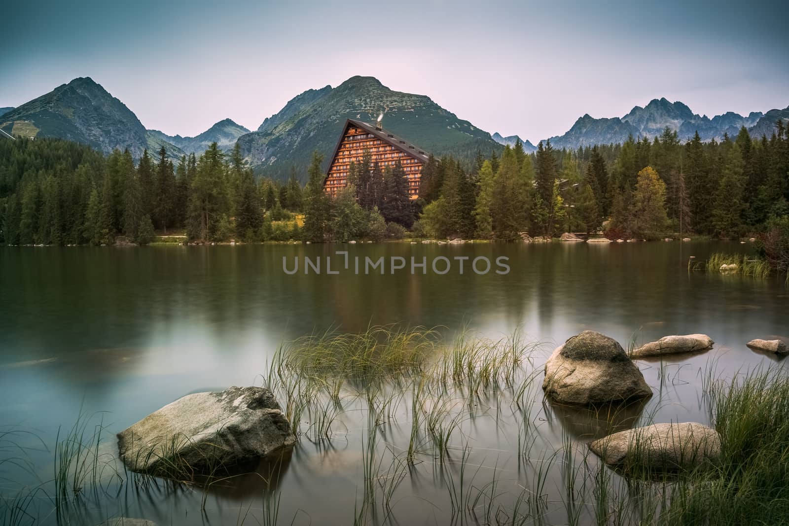 Strbske Pleso Mountain Lake in High Tatras Mountains, Slovakia with Rocks and Grass in Foreground
