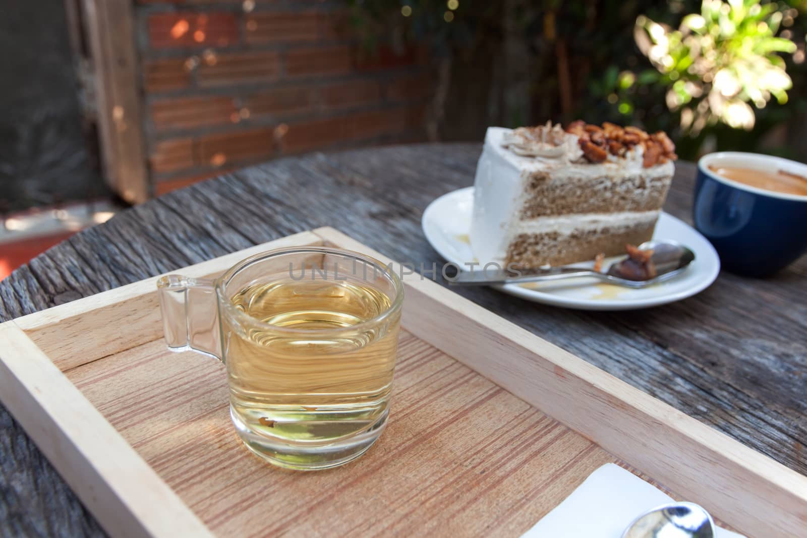 hot tea and Coffee cake with topping almond on white plate  and hot espresso on old wood table