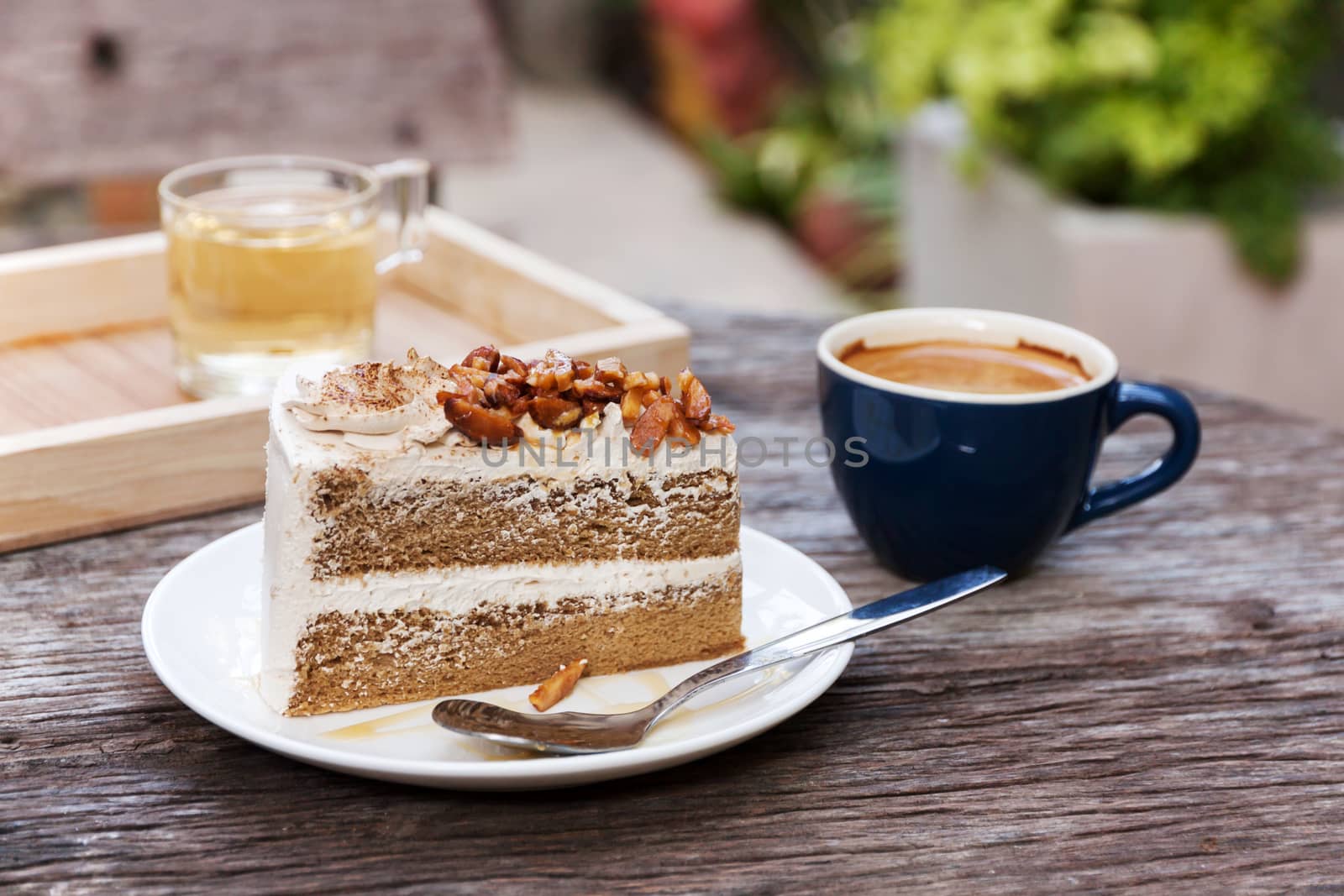 Coffee cake with topping almond on white plate  and hot espresso on old wood table