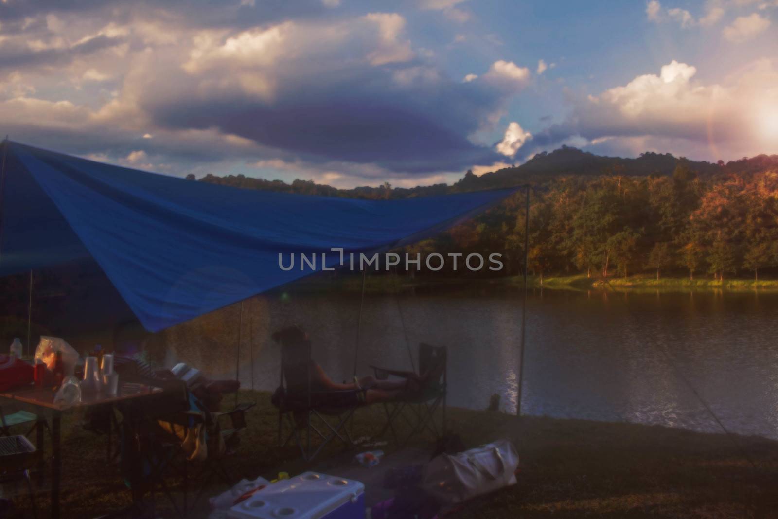 Tent with tourists relaxing at the lake.