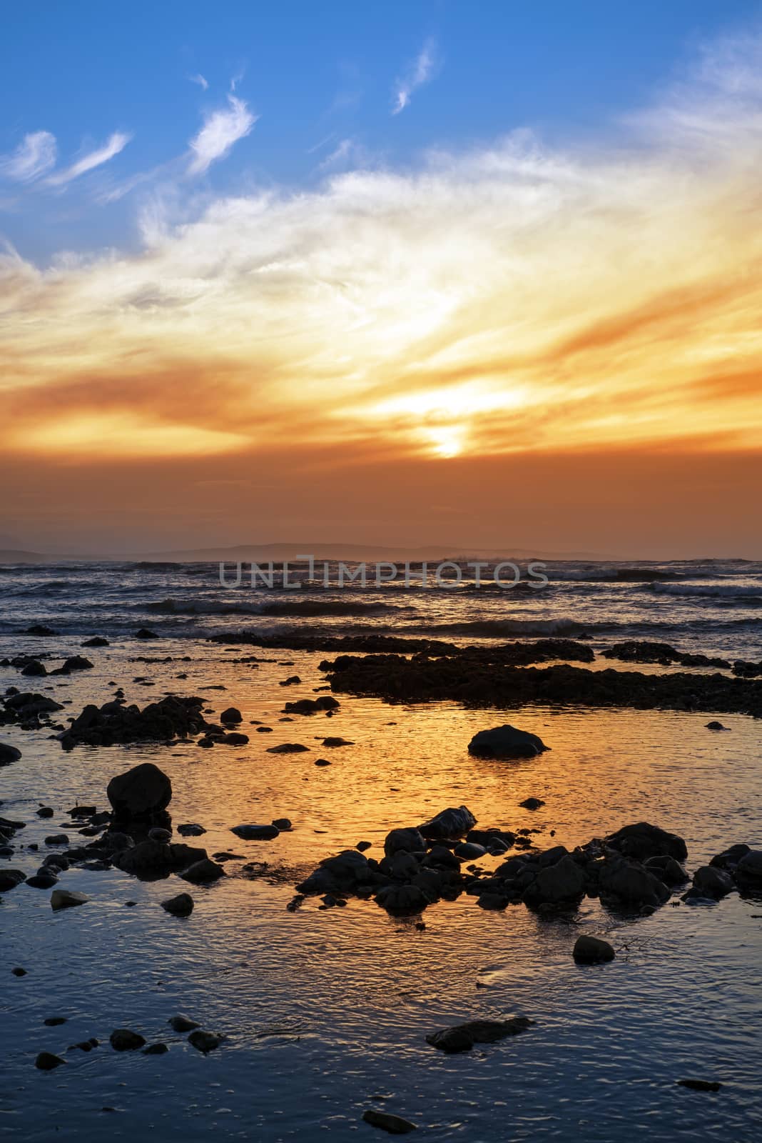 reflections at rocky beach near ballybunion on the wild atlantic way ireland with a beautiful yellow sunset