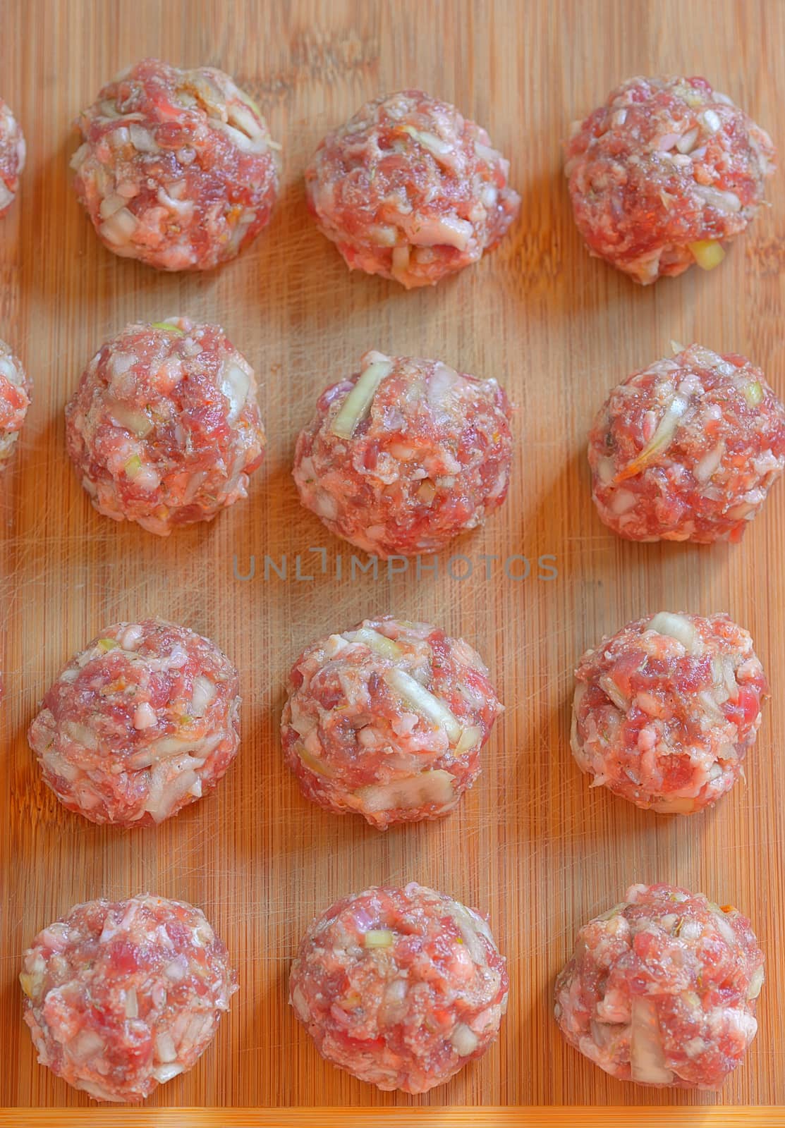 Raw Uncooked Meatballs on wooden plate