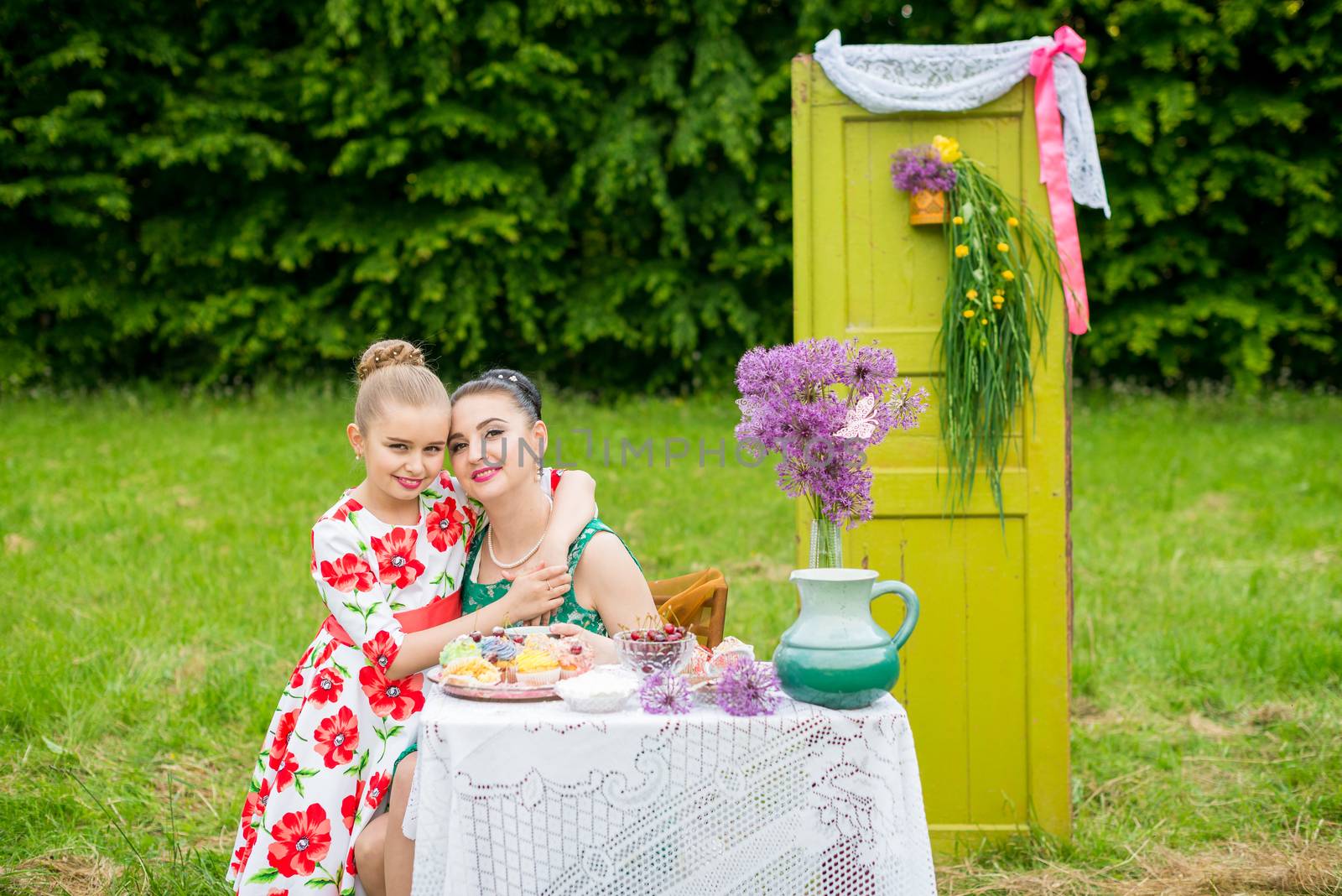 mother with daughter have a breakfast in the garden