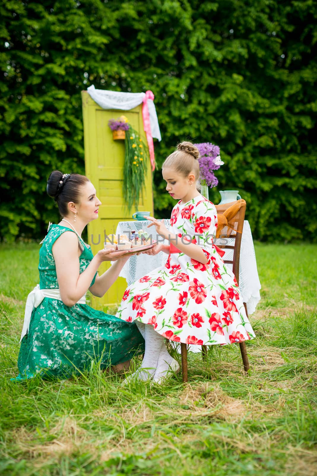 mother with daughter have a breakfast in the garden